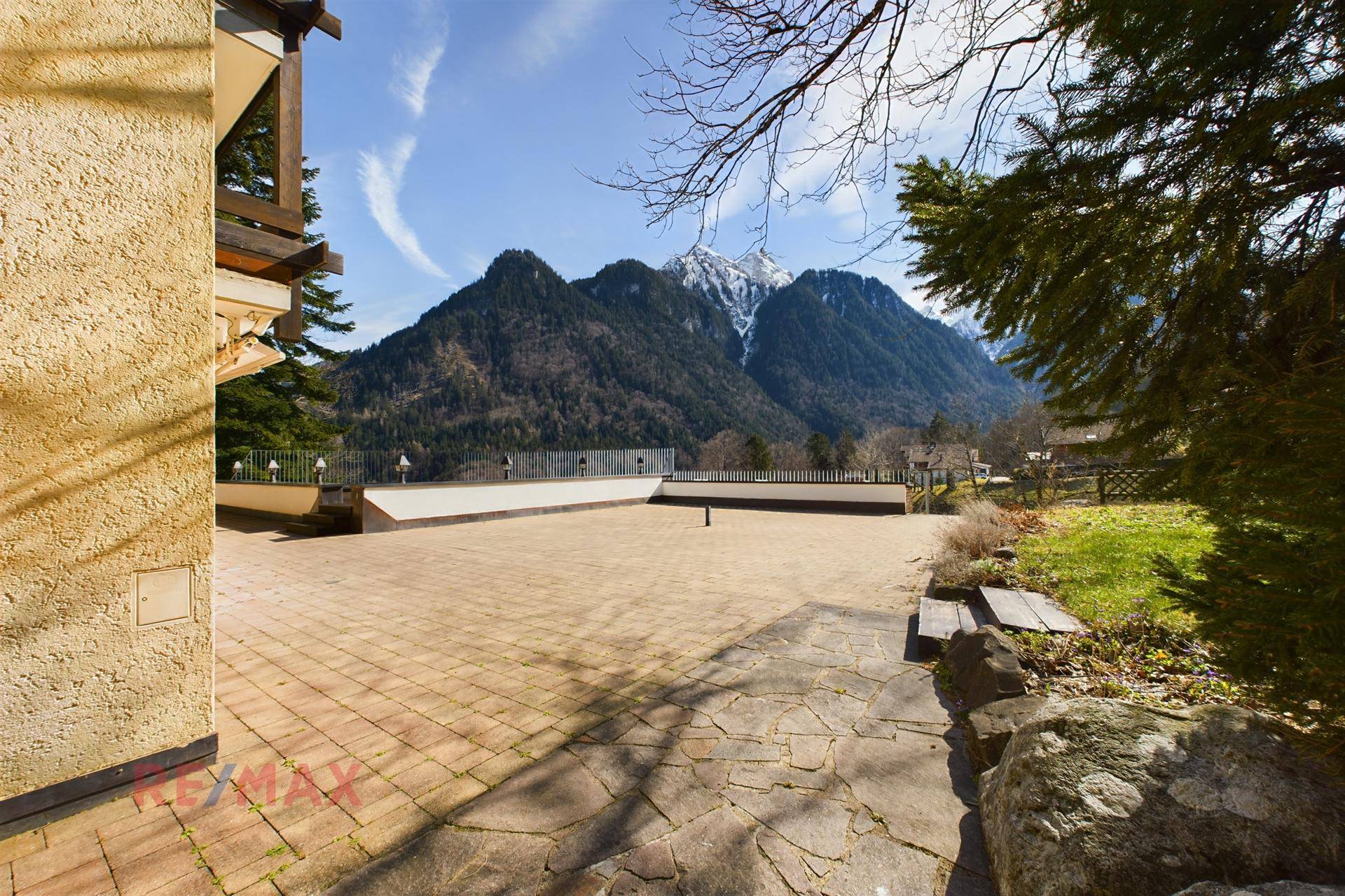 Große gepflasterte Terrasse mit Blick auf die majestätischen Berge, ideal für Entspannung im Freien.