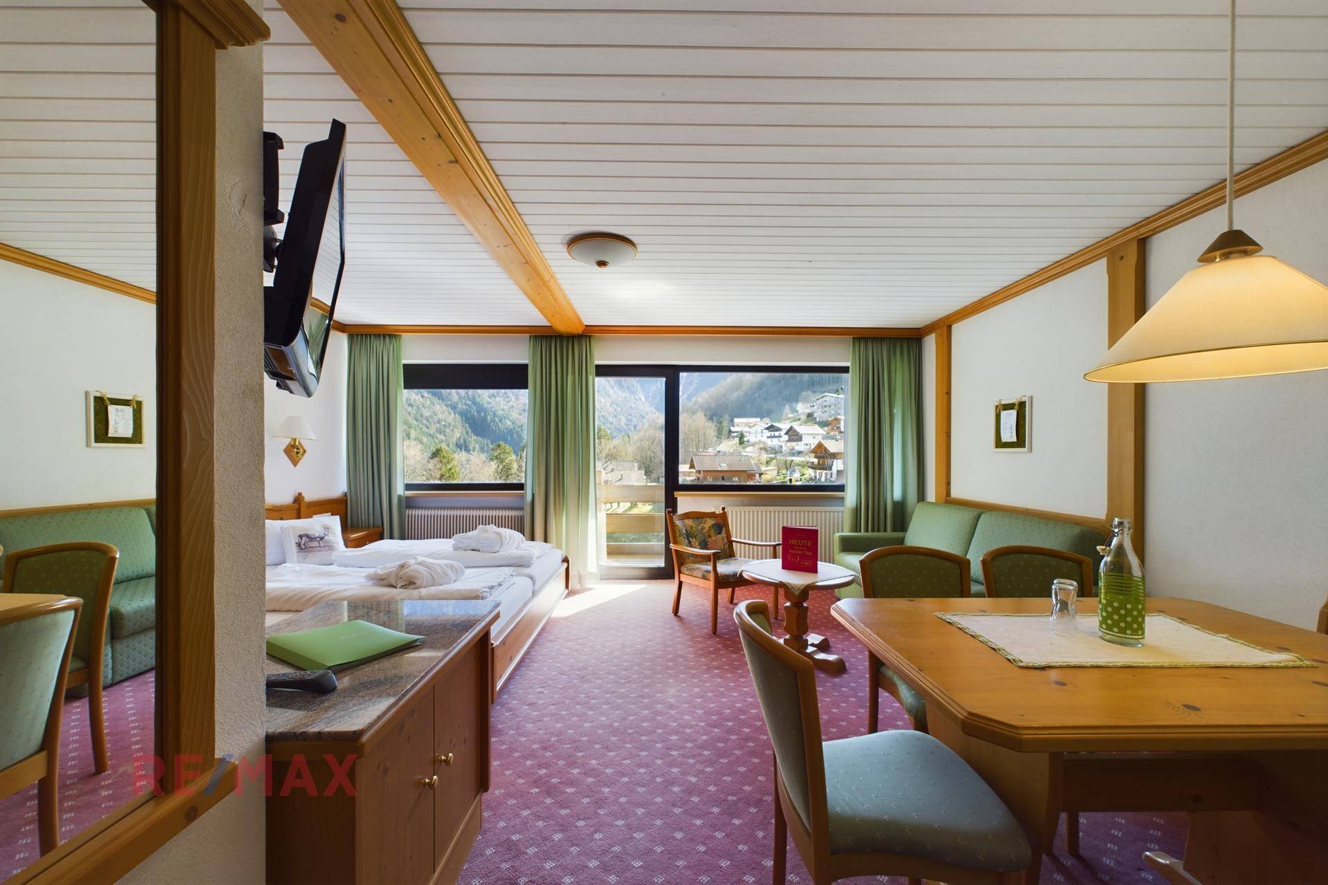 Geräumiges Schlafzimmer mit Essbereich, Teppichboden und großen Fenstern mit Bergblick.