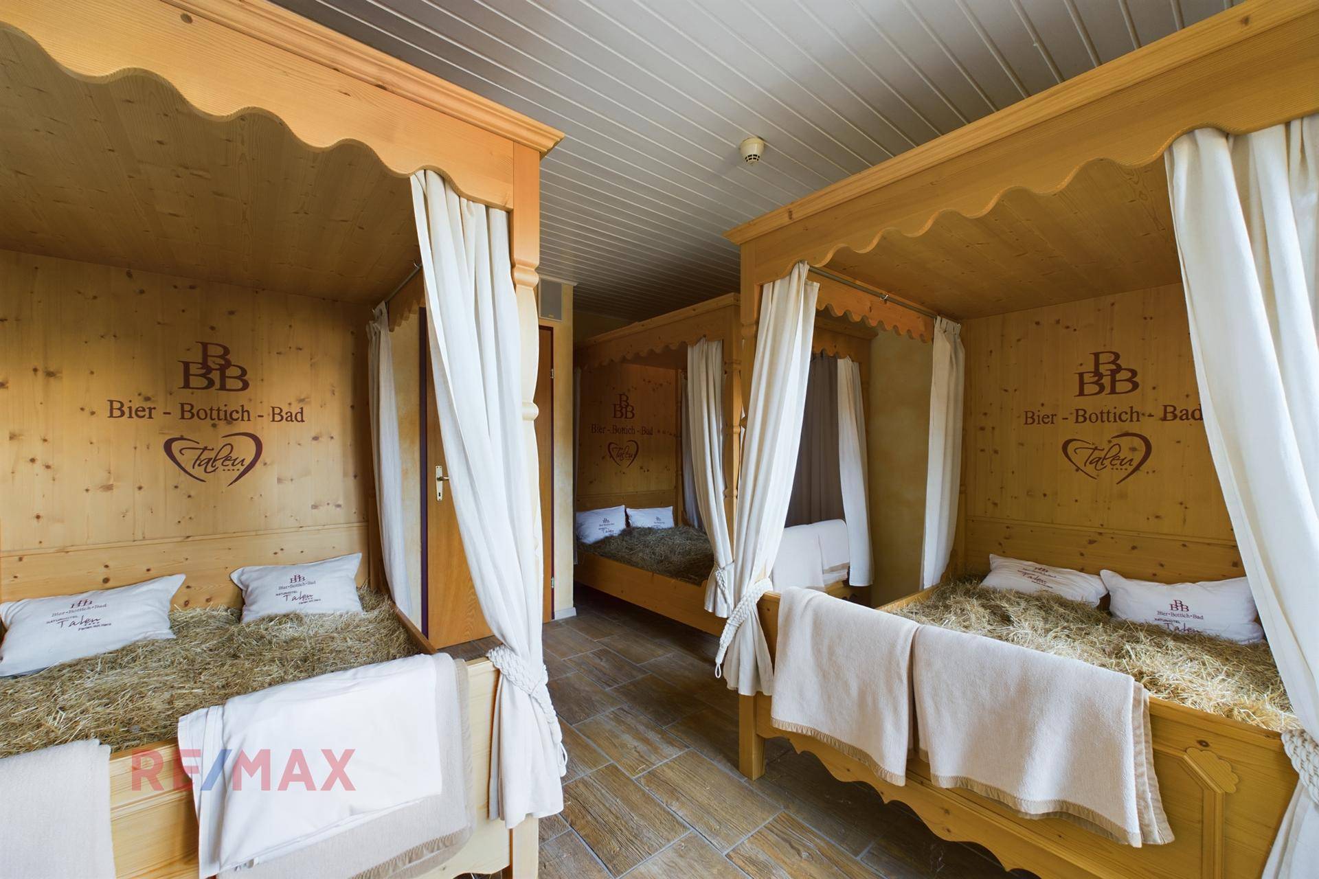 Entspannungsbereich mit Heubetten in Holzkabinen, ideal für traditionelle Wellnessanwendungen.