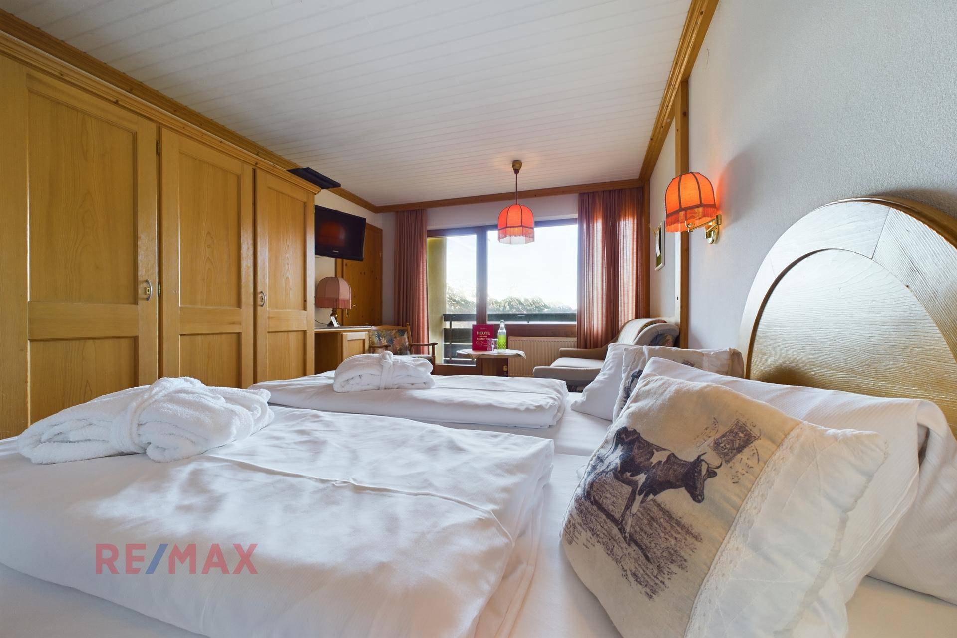 Gemütliches Schlafzimmer mit Holzmöbeln, Doppelbett und Blick auf die umliegende Natur.