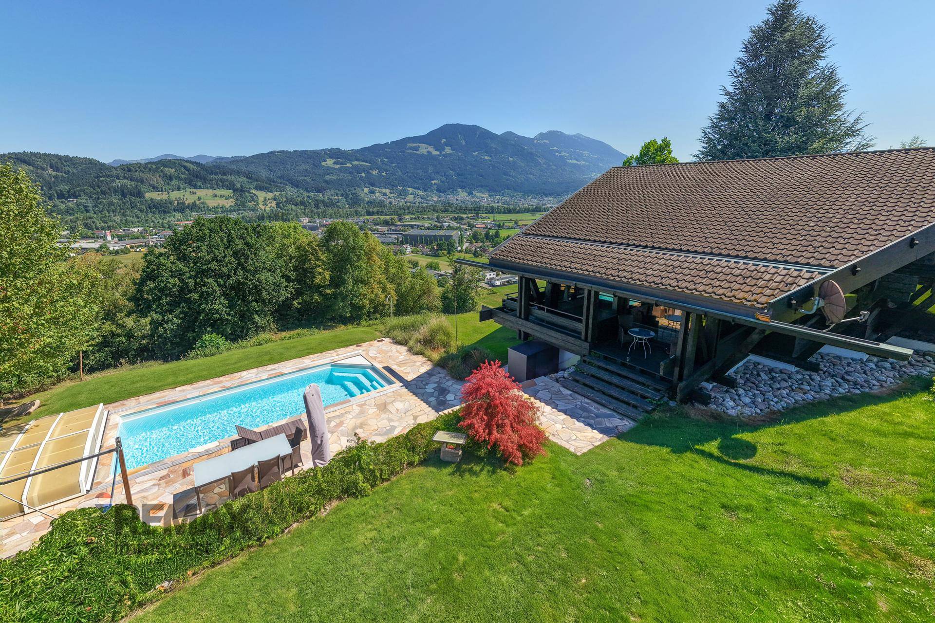 Panoramablick auf das Anwesen mit Pool, Terrasse und weitreichender Landschaft im Hintergrund.