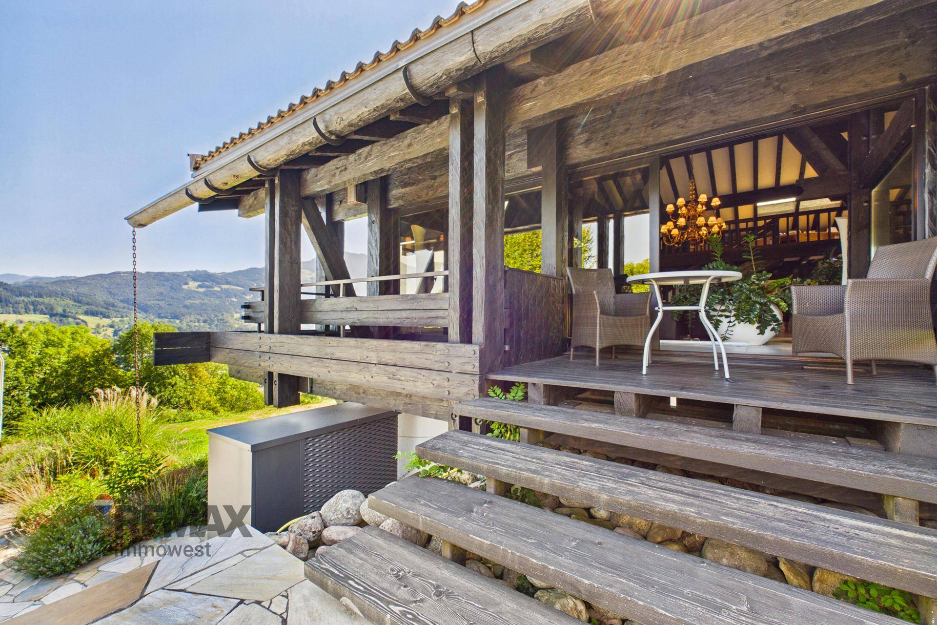 Überdachte Terrasse mit Sitzgelegenheiten und weitem Blick auf die umliegende Landschaft.