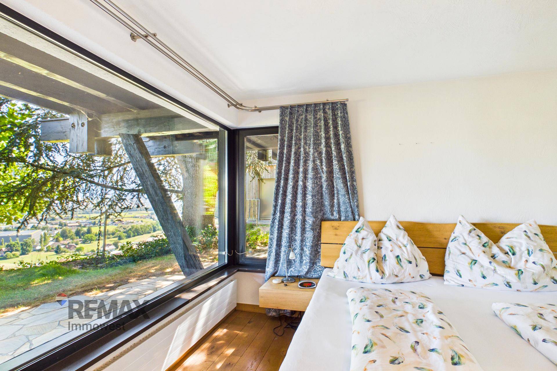 Schlafzimmer mit großen Fenstern, die einen weiten Blick auf die Landschaft bieten.