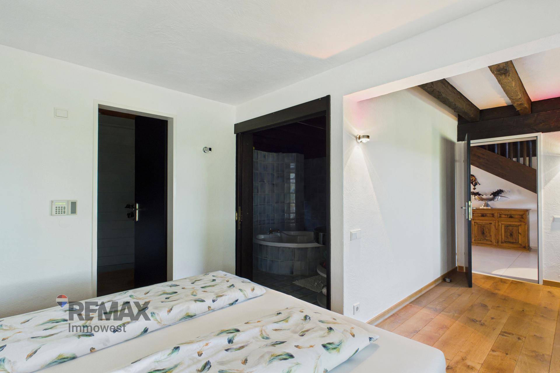 Schlafzimmer mit Zugang zu einem Badezimmer und Blick auf den Flur.