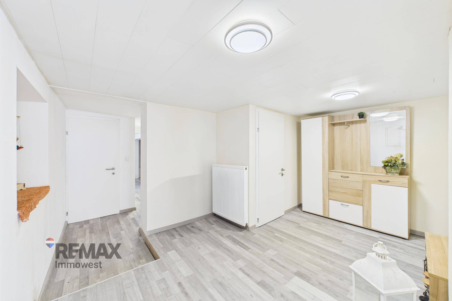 Heller Eingangsbereich mit Garderobe und modernem Laminatboden.