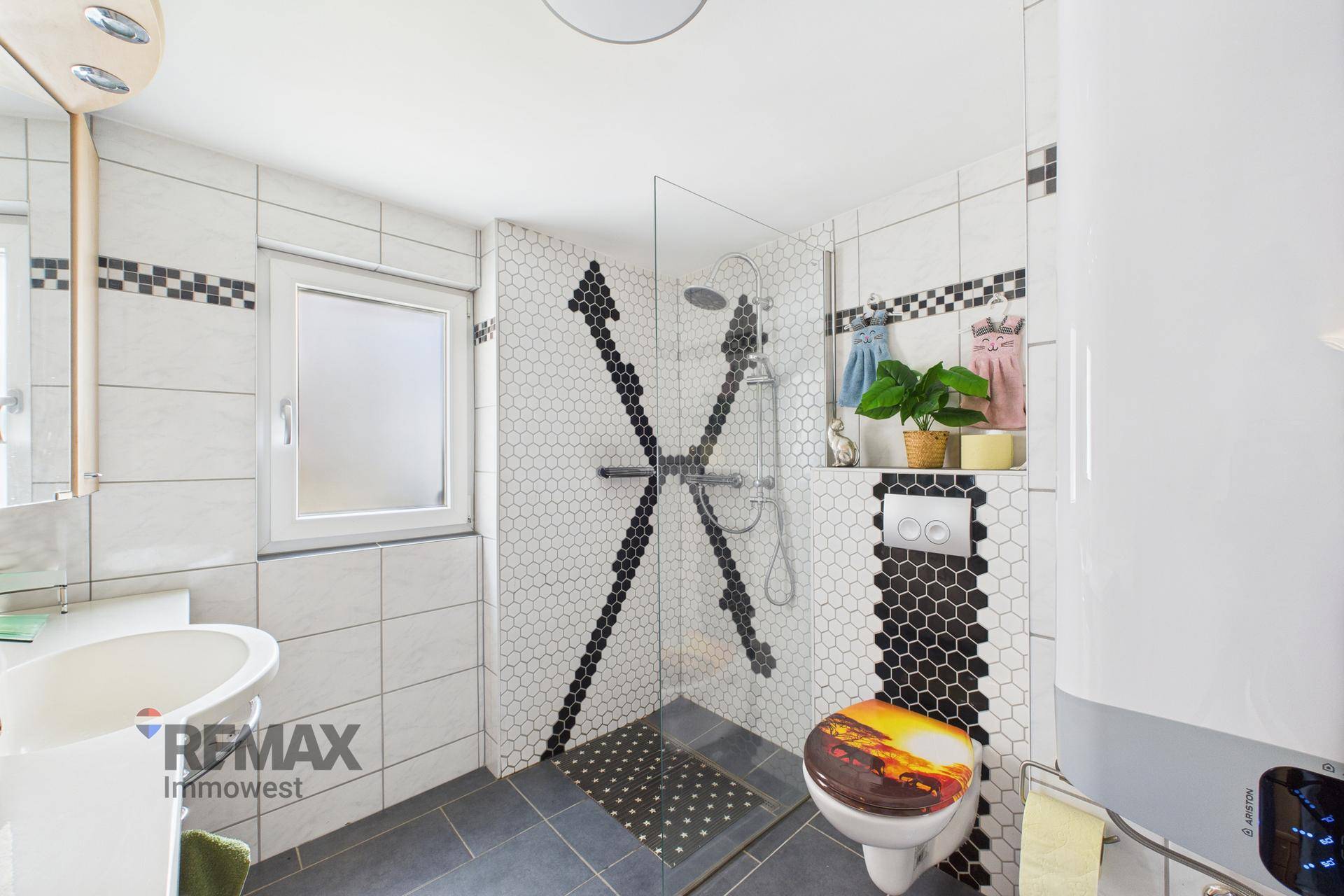 Modernes Badezimmer mit Duschkabine, Wand-WC und dekorativen Fliesen.