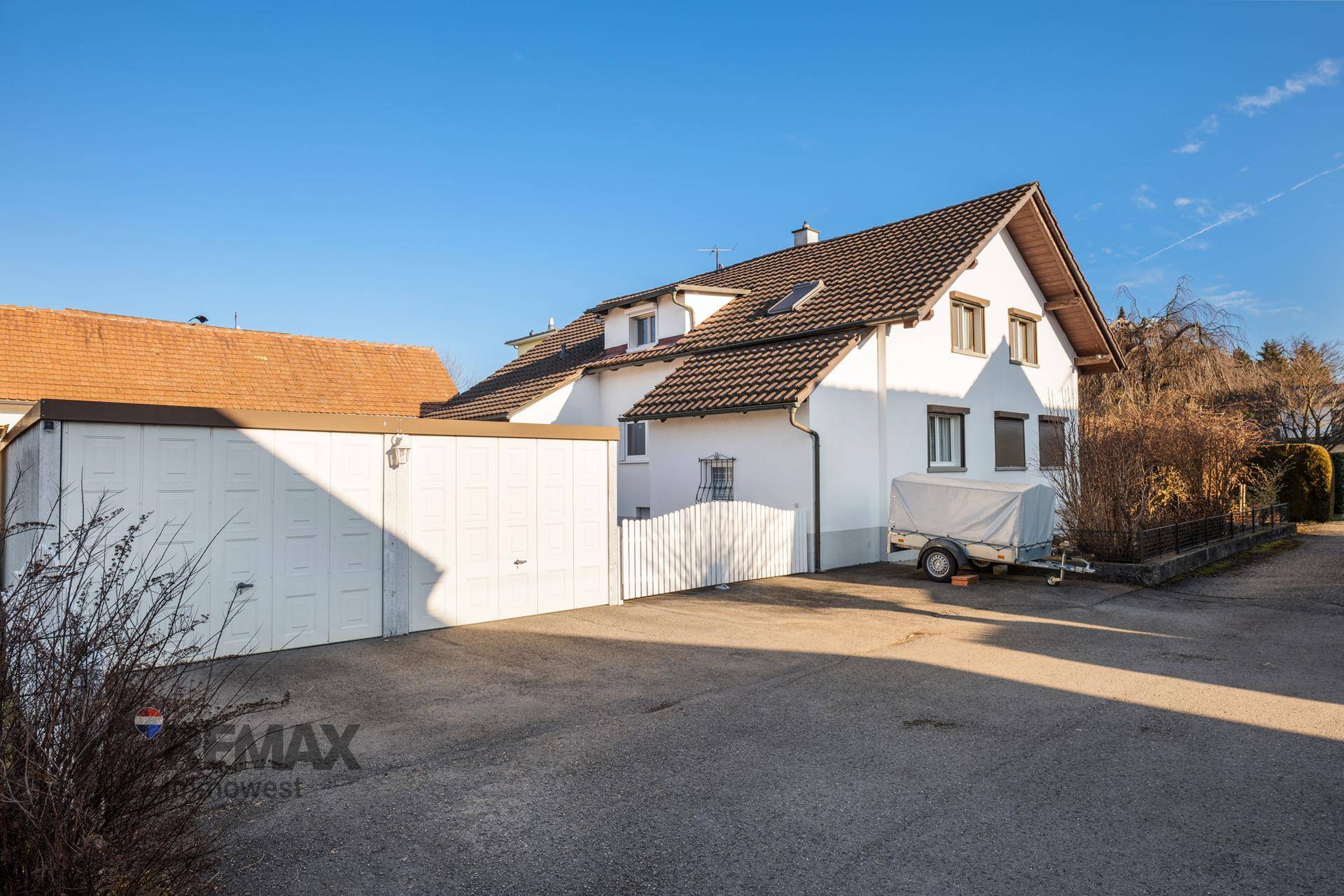 Außenansicht des Hauses mit Doppelgarage und gepflasterter Einfahrt.