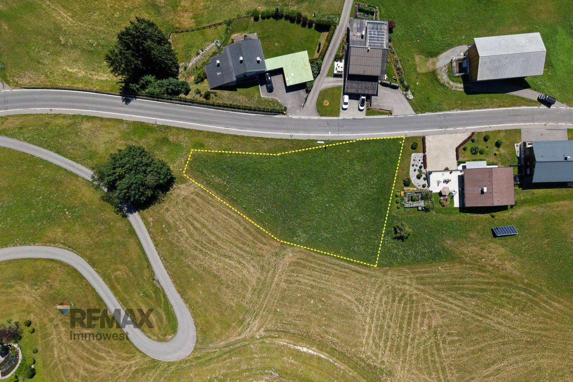 Draufsicht auf ein Grundstück mit angrenzenden Straßen und weiteren Gebäuden in ländlicher Umgebung.