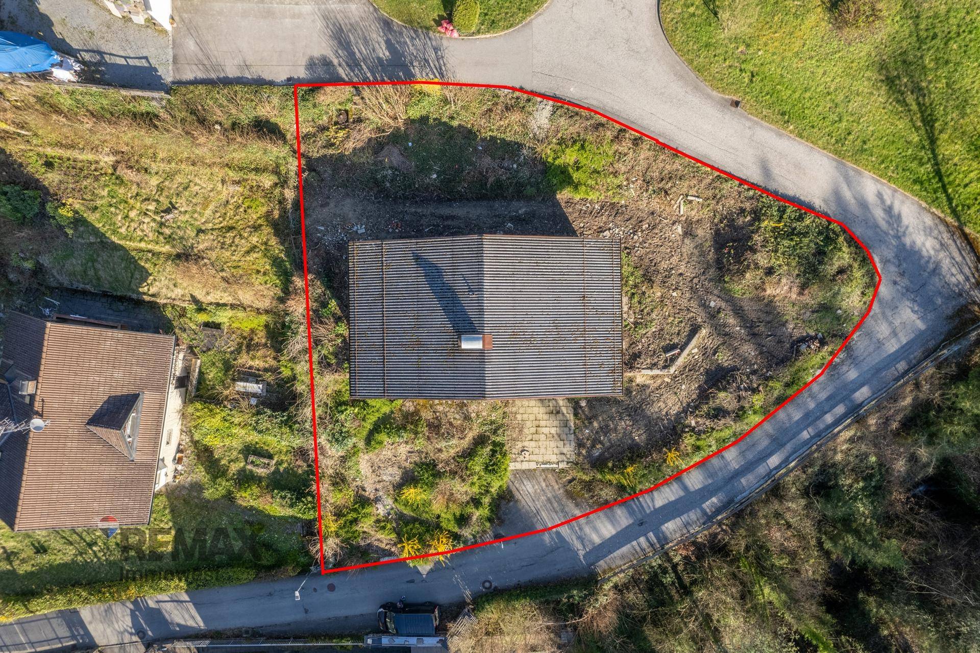 Luftaufnahme des Grundstücks mit roter Umrandung und dem Dach des Hauses.