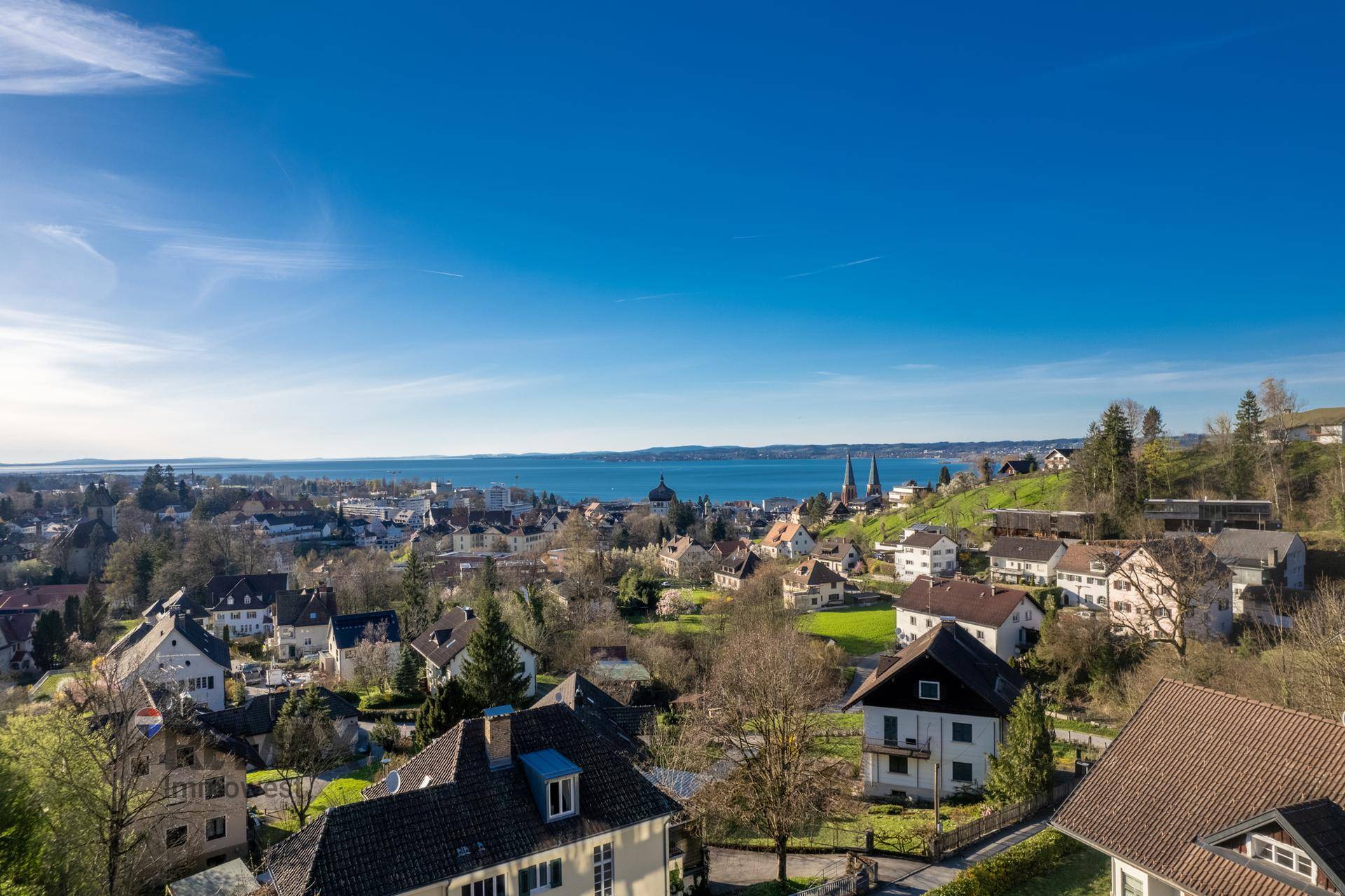 Panoramablick über die Stadt und den See unter einem klaren blauen Himmel.