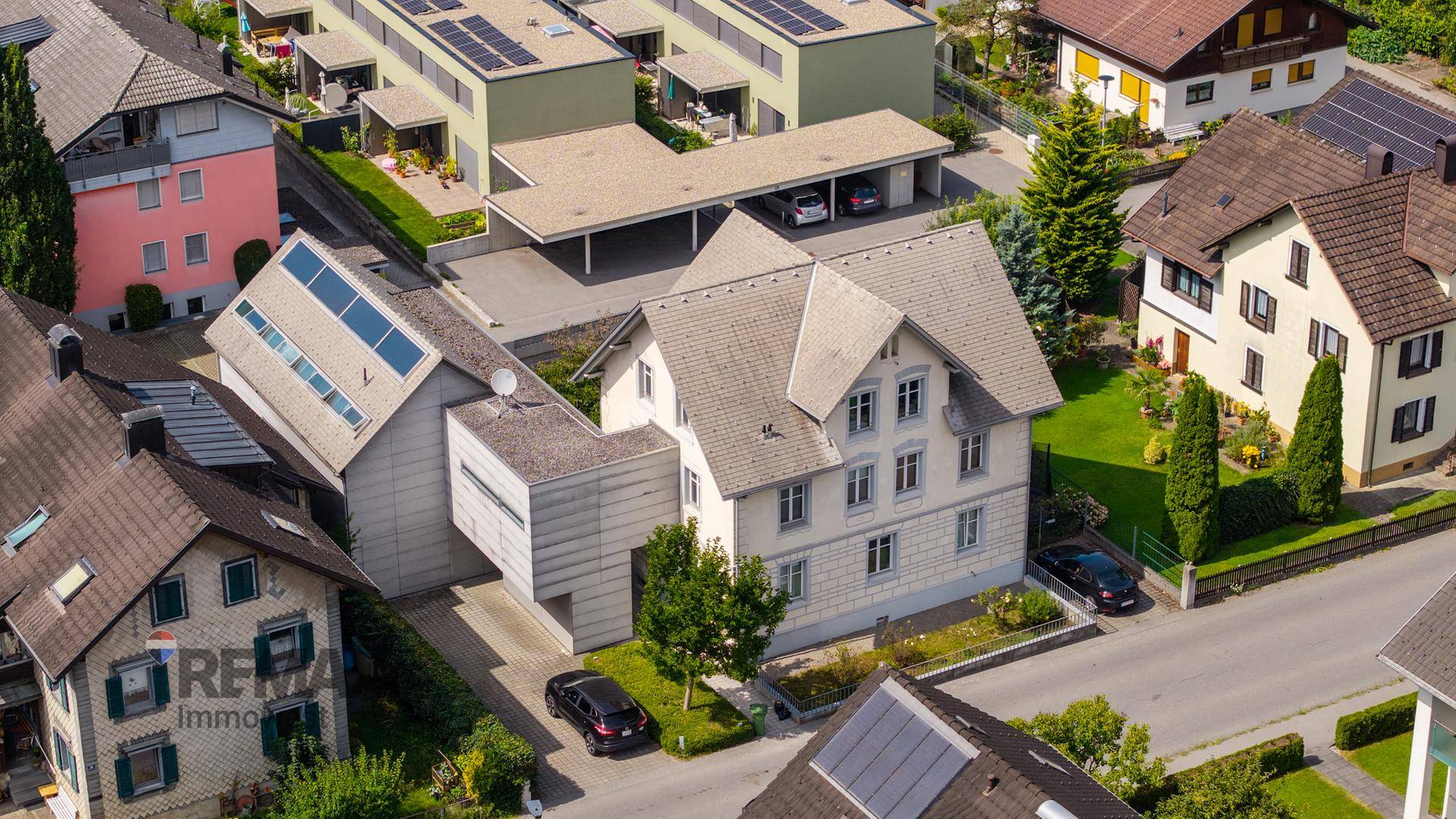 Luftaufnahme des Anwesens und der umliegenden Nachbarschaft mit verschiedenen Häusern und Solaranlagen.