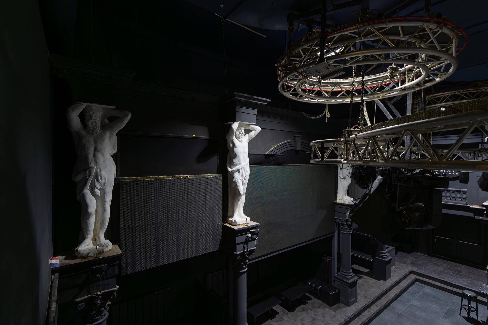 Detailansicht des Tanzsaals mit Statuen, Beleuchtung und Metallkonstruktionen an der Decke.