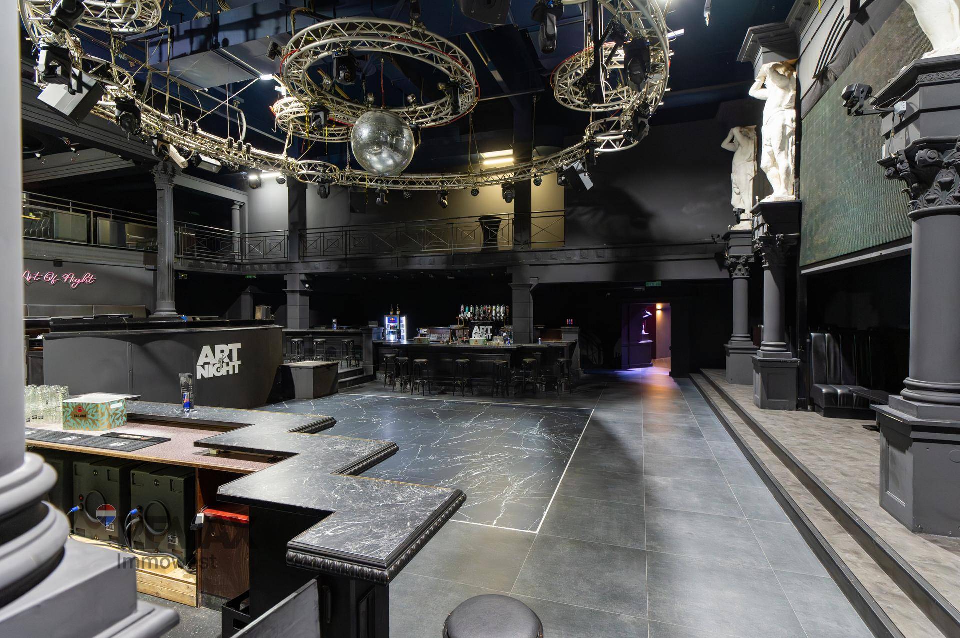 Weitläufiger Tanzsaal mit mehreren Bars, Sitzgelegenheiten und aufwendiger Deckenbeleuchtung.