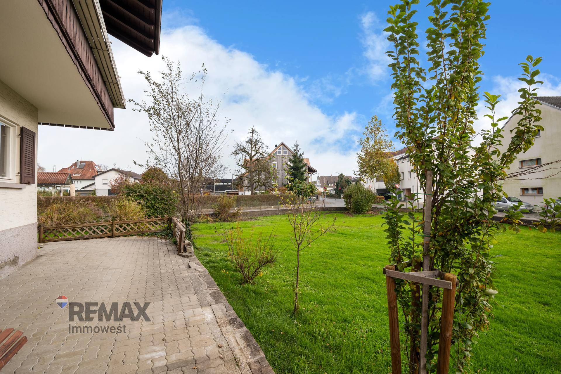Geräumige Terrasse mit Blick auf den grünen Garten und die umliegende Wohnbebauung.