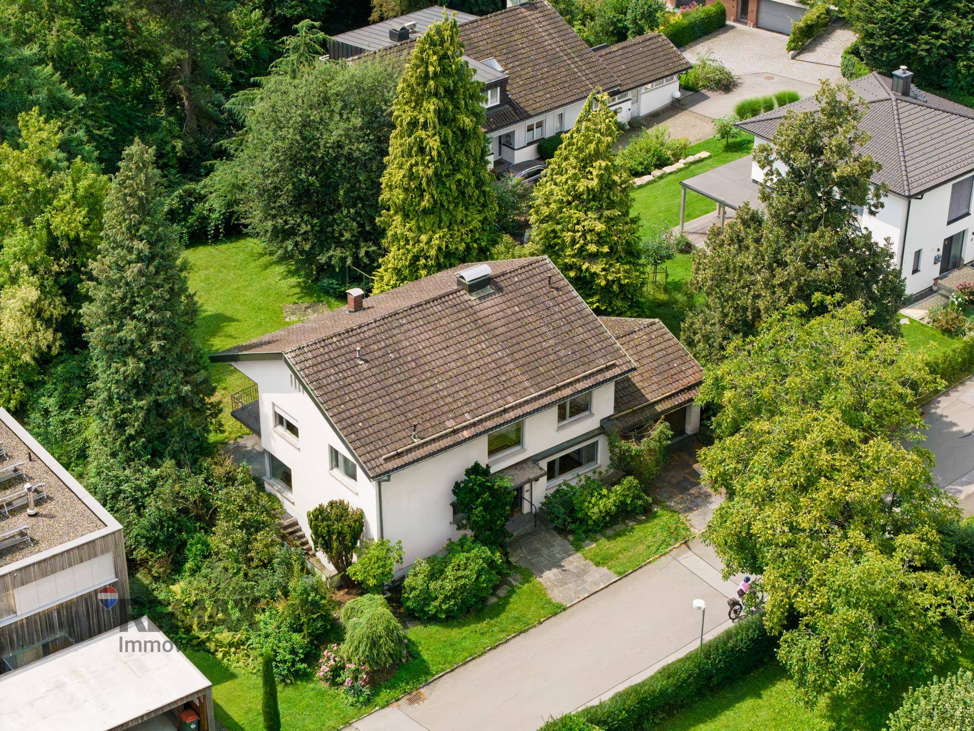 Luftaufnahme des Einfamilienhauses mit Satteldach und umliegenden Gärten in einer Wohnsiedlung.