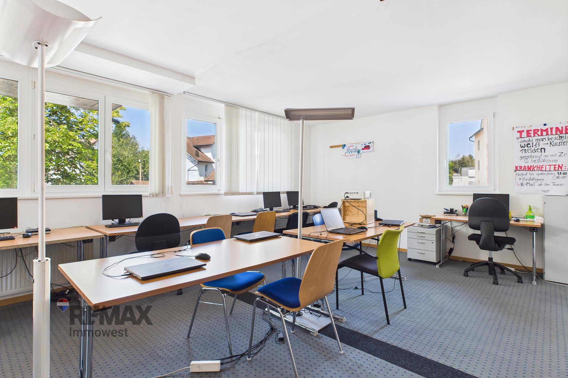 Computerraum mit mehreren Arbeitsplätzen, Bildschirmen und Laptops, ideal für IT-Schulungen und Kurse.