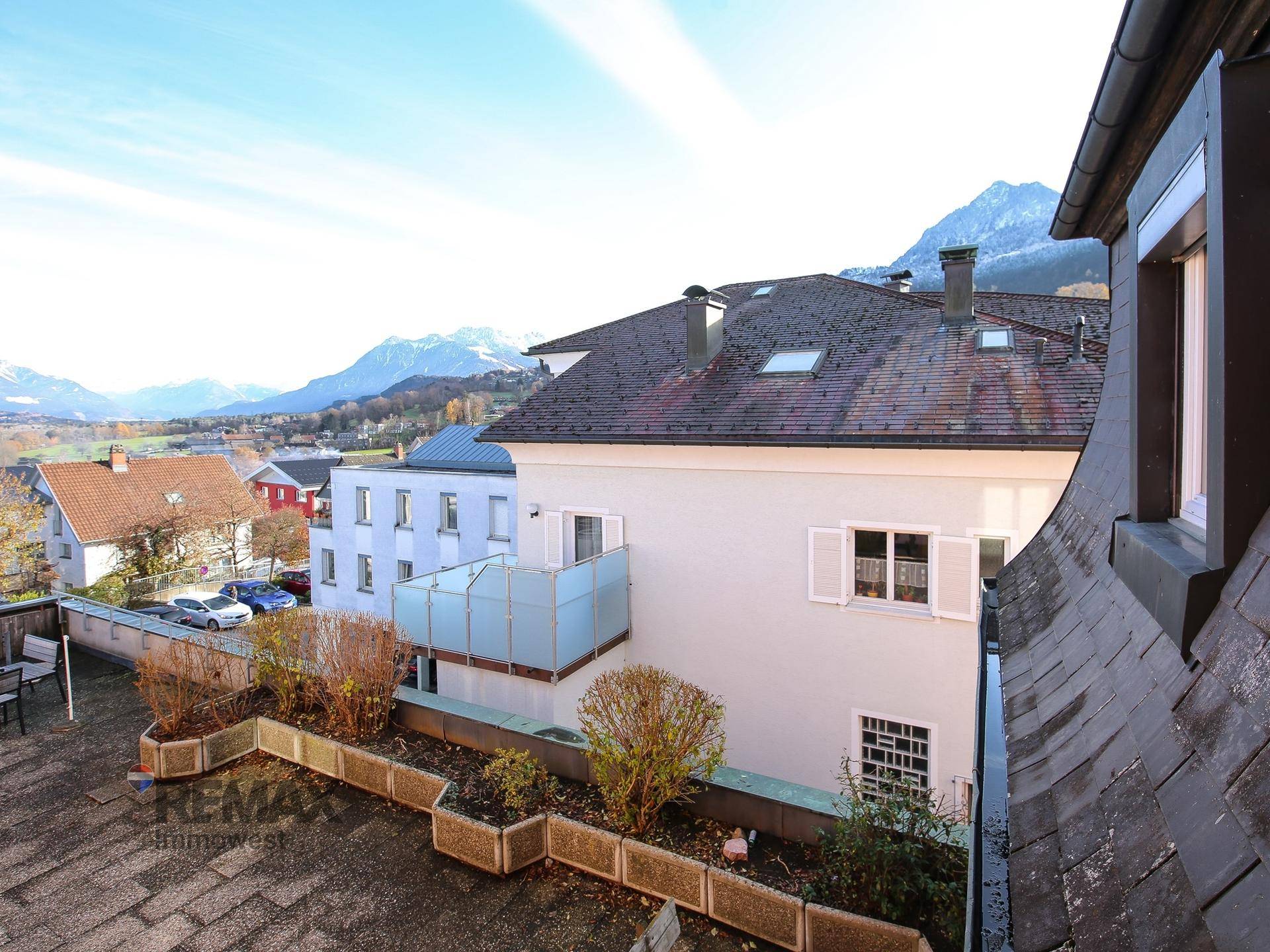 Panoramablick auf die umliegende Berglandschaft und die Dächer der Stadt.