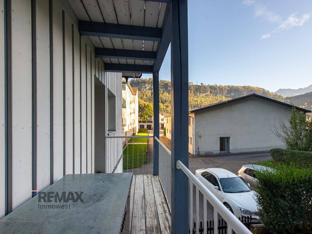 Balkon mit Holzboden und Blick auf die Umgebung und die Berge.