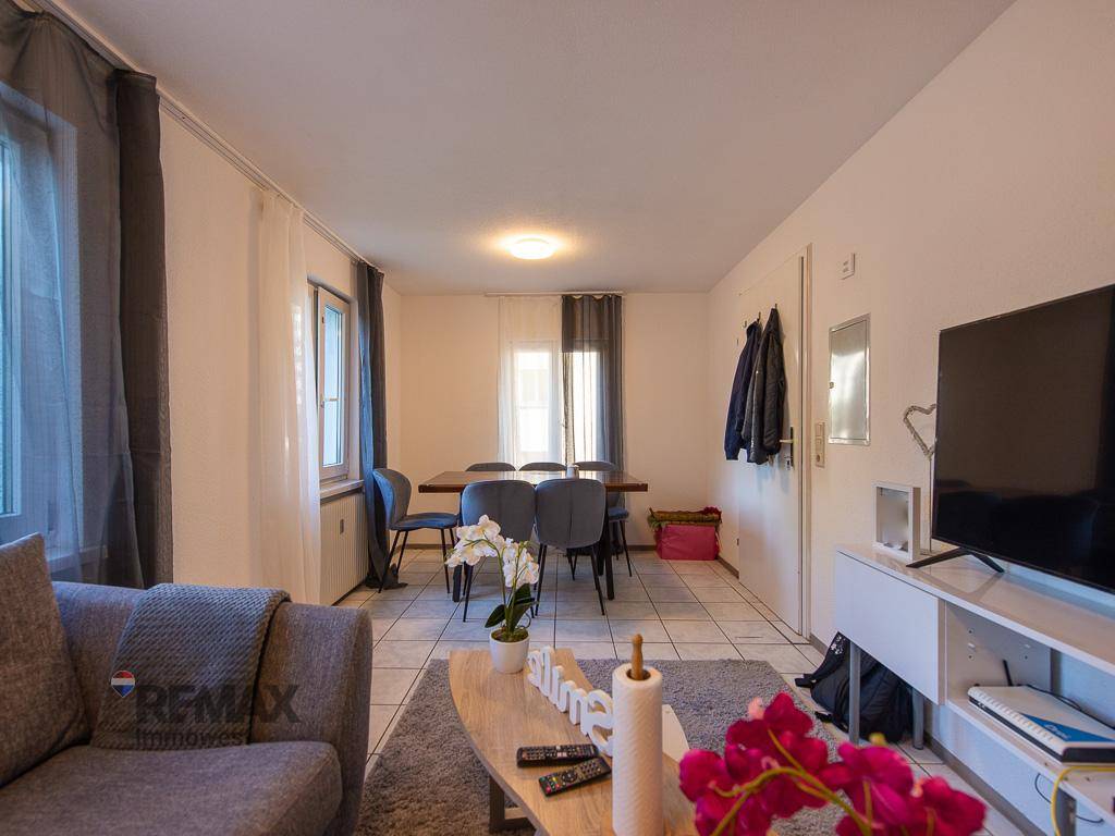 Kombinierter Wohn- und Essbereich mit Fliesenboden, gemütlichem Sofa und Esstisch für gesellige Stunden.