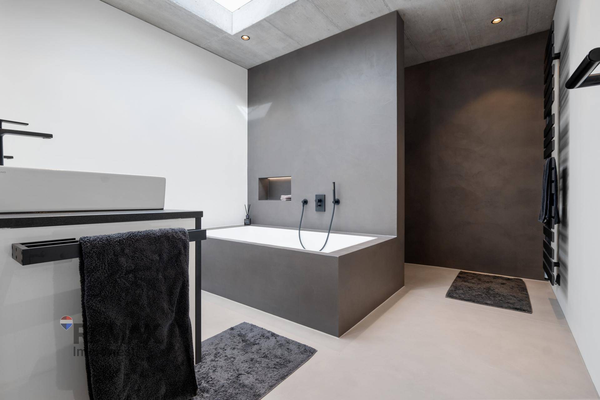 Geräumiges Badezimmer mit Badewanne, modernem Waschbecken und beheiztem Handtuchhalter.