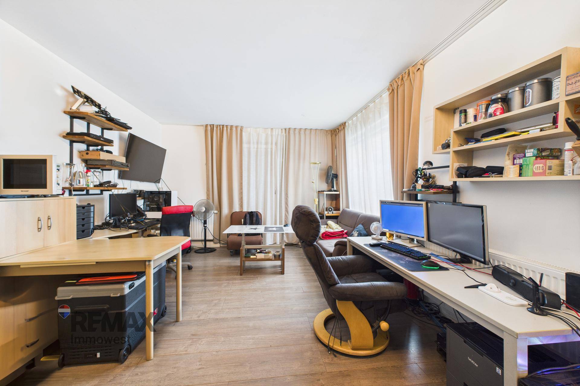 Großzügiger Raum als Büro mit mehreren Arbeitsplätzen und Fenstern, hell und funktional.