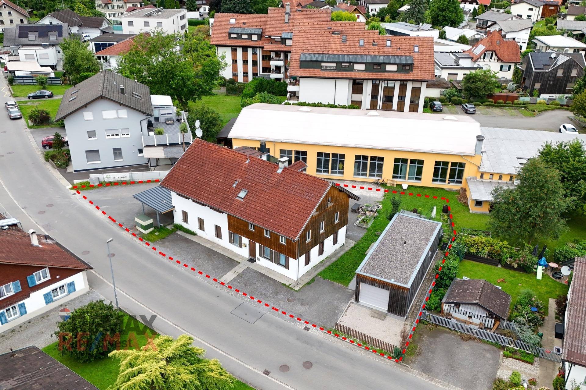 Luftaufnahme des Anwesens mit Wohnhaus, Nebengebäuden und Grundstücksgrenze, umgeben von Bebauung.