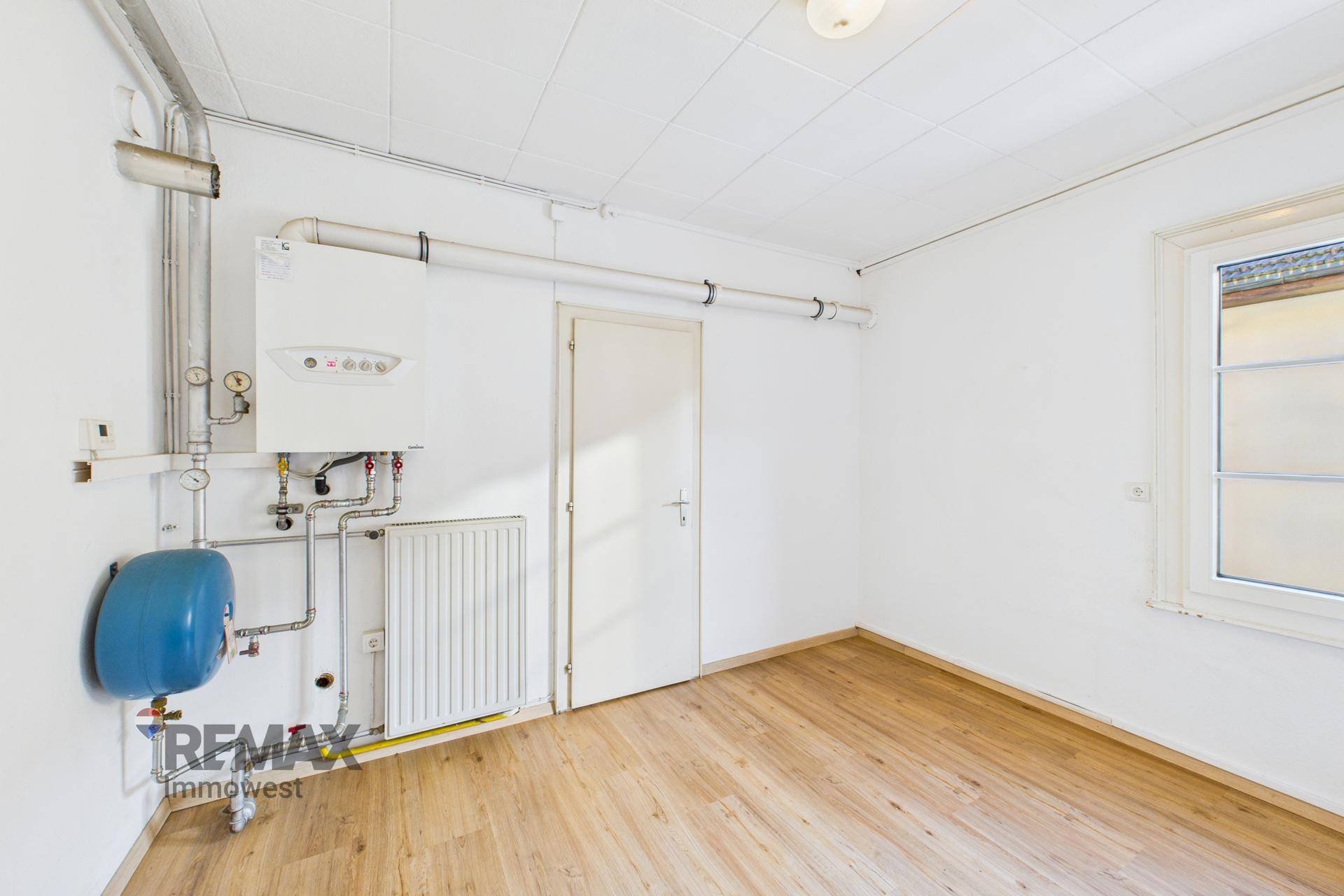 Raum mit Heizungsanlage, Heizkörper und einem Fenster, ideal als Abstellraum.