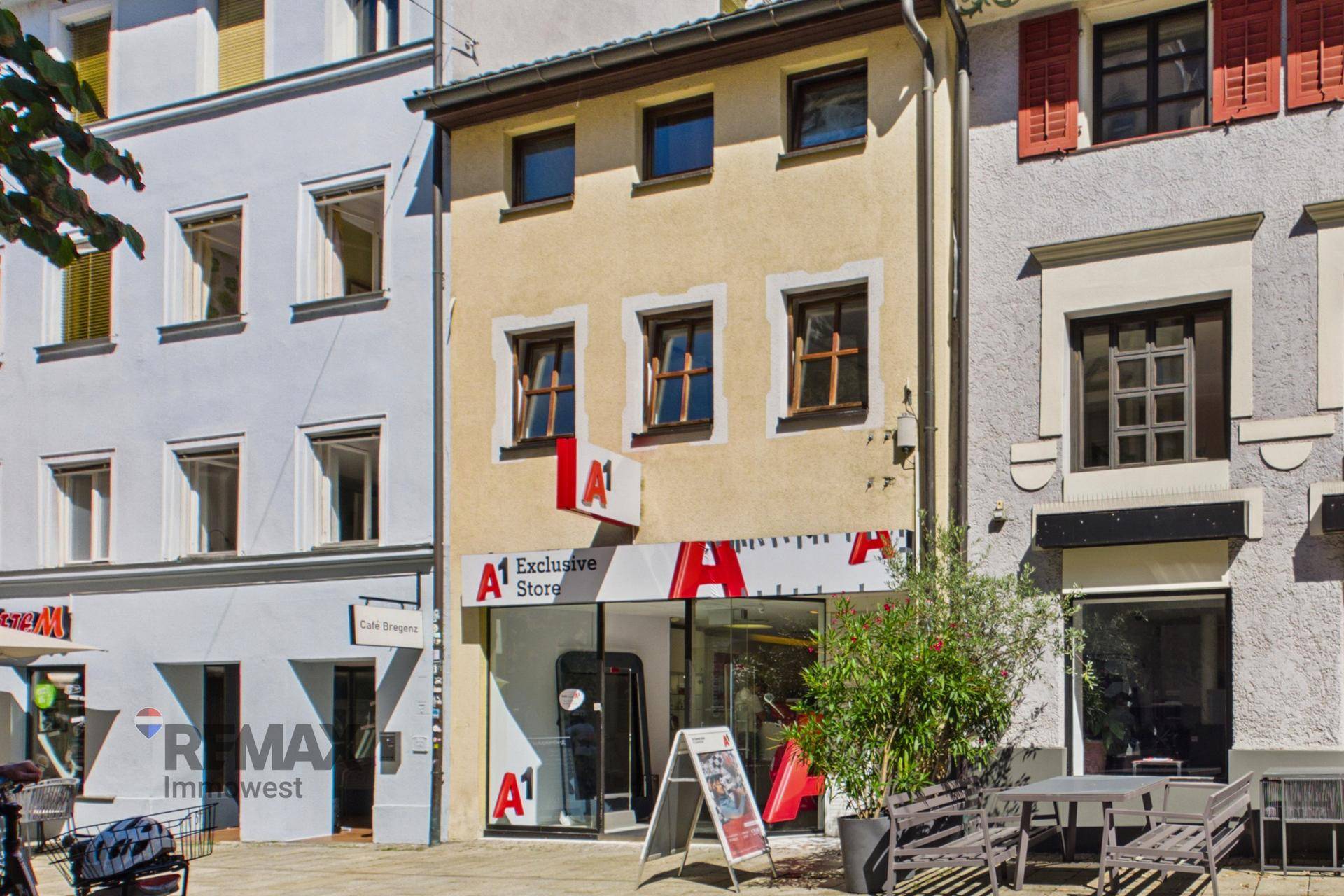 Historisches Gebäude mit Geschäftsfläche im Erdgeschoss und Wohnungen darüber, an einer belebten Straße.