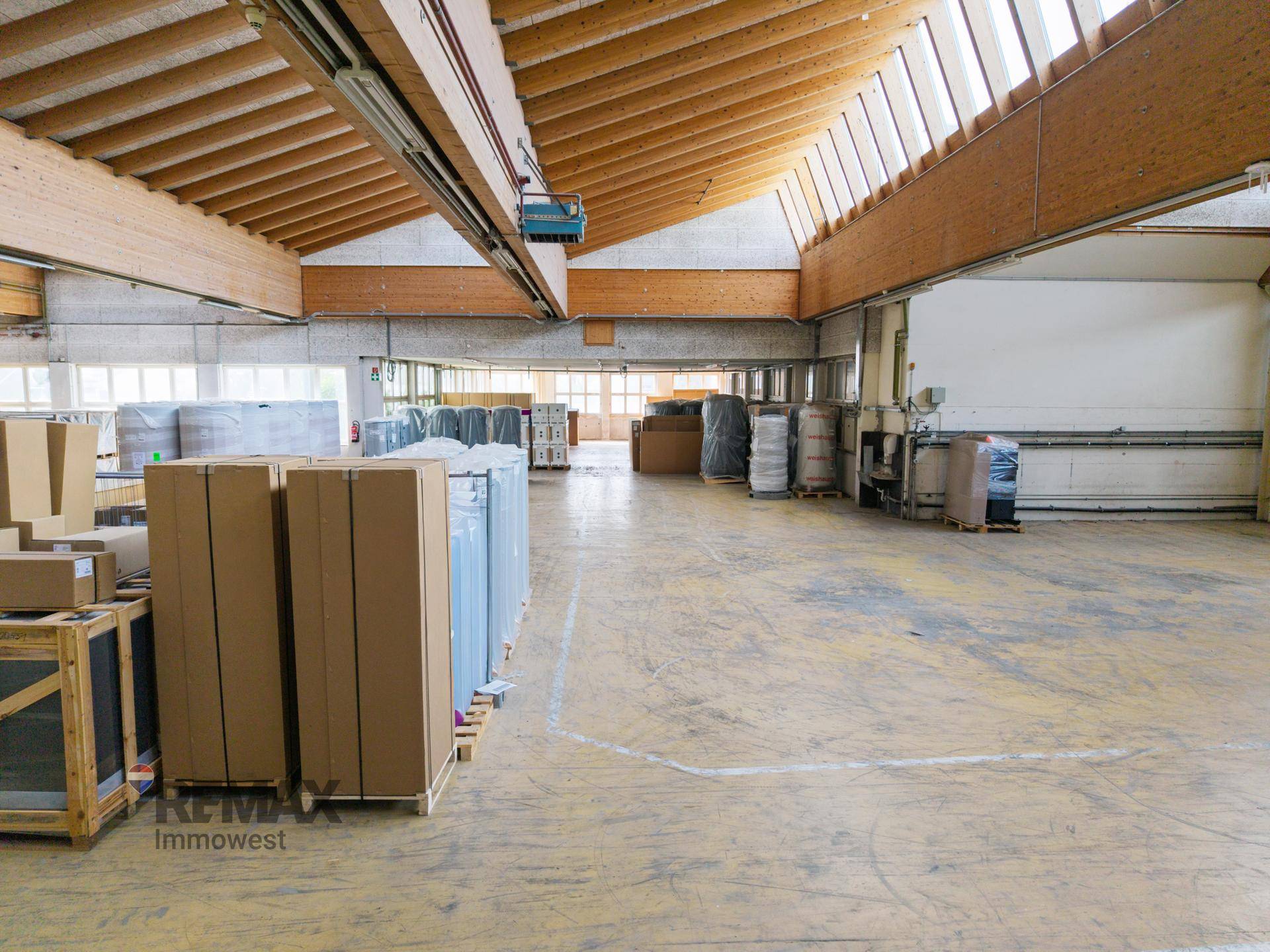 Weitläufige Lagerfläche mit sichtbaren Holzträgern und Betonboden, ideal für Logistik und Lagerung.