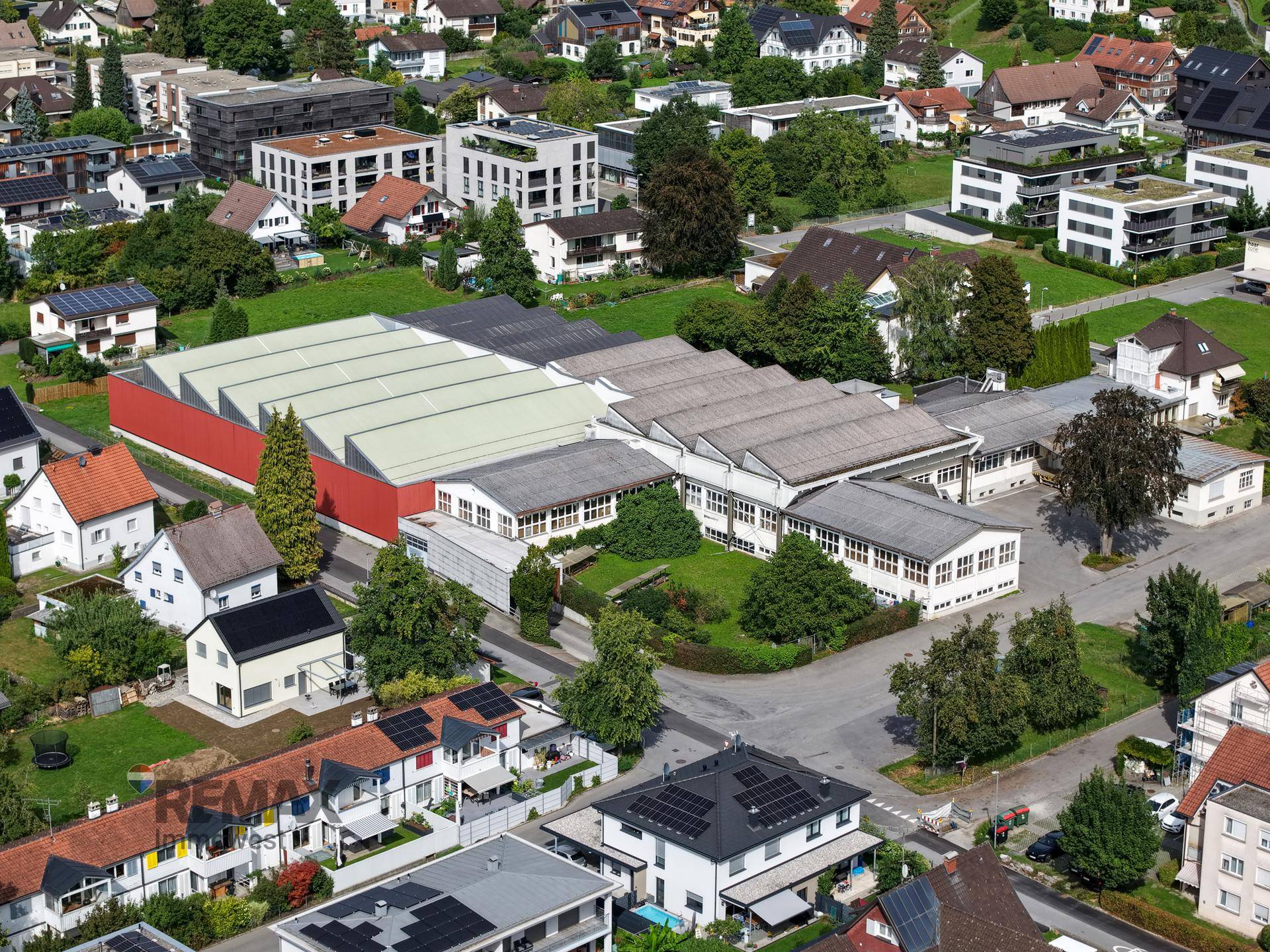 Überblick aus der Vogelperspektive über das Gewerbeareal und die umliegende Wohnbebauung mit vielen Solaranlagen.