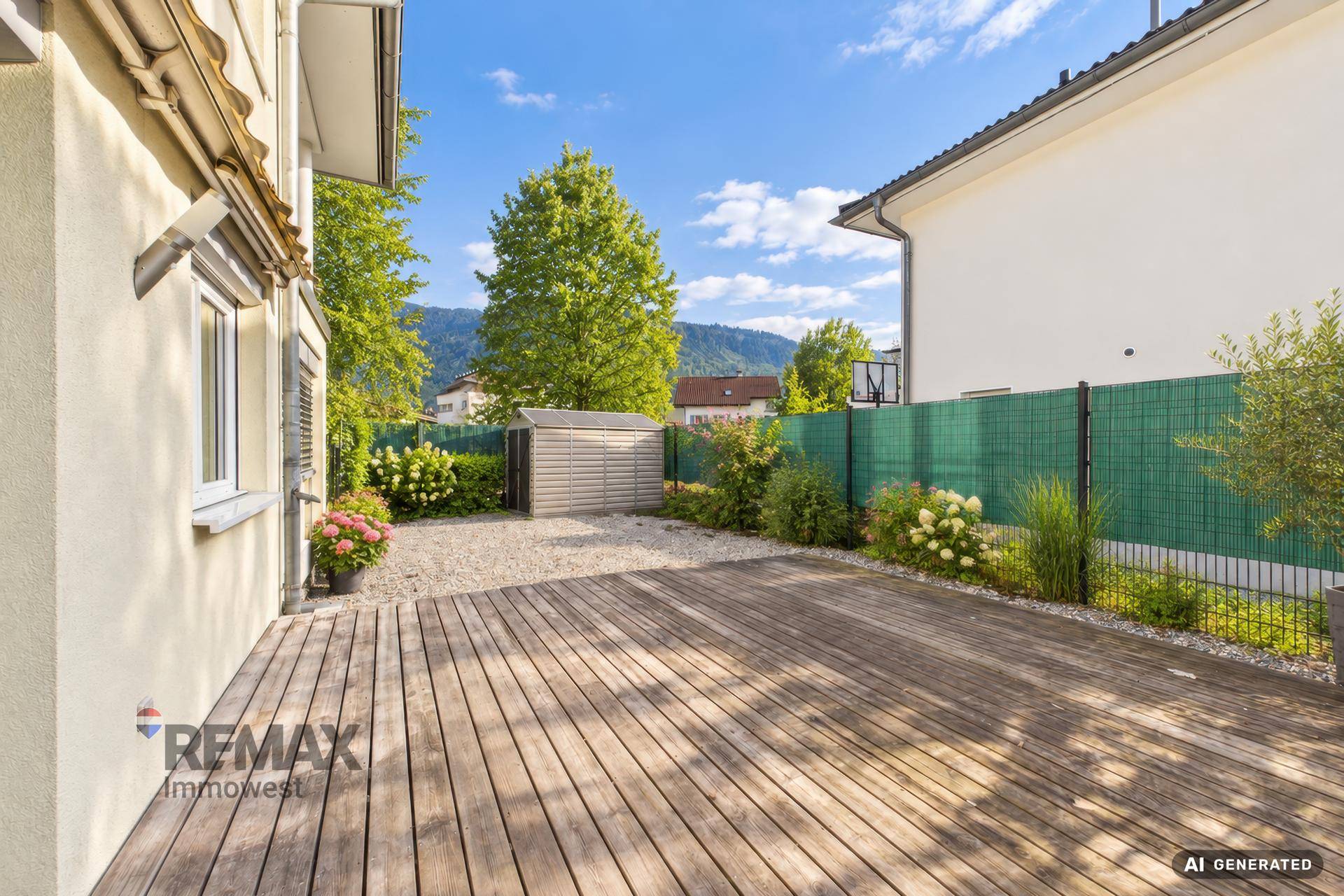 Geräumige Holzterrasse mit Gartenhaus und Blick auf die grüne Umgebung.
