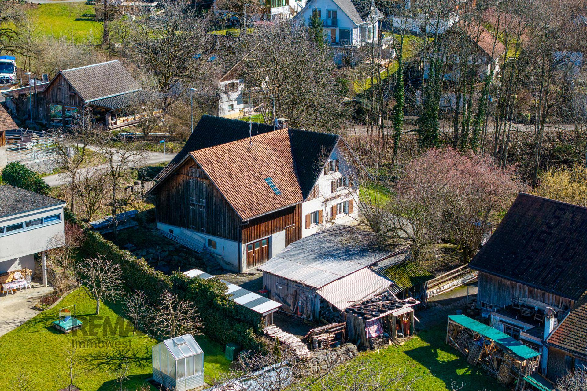 Vogelperspektive des Anwesens mit Haupthaus, Nebengebäude und Gartenbereich.