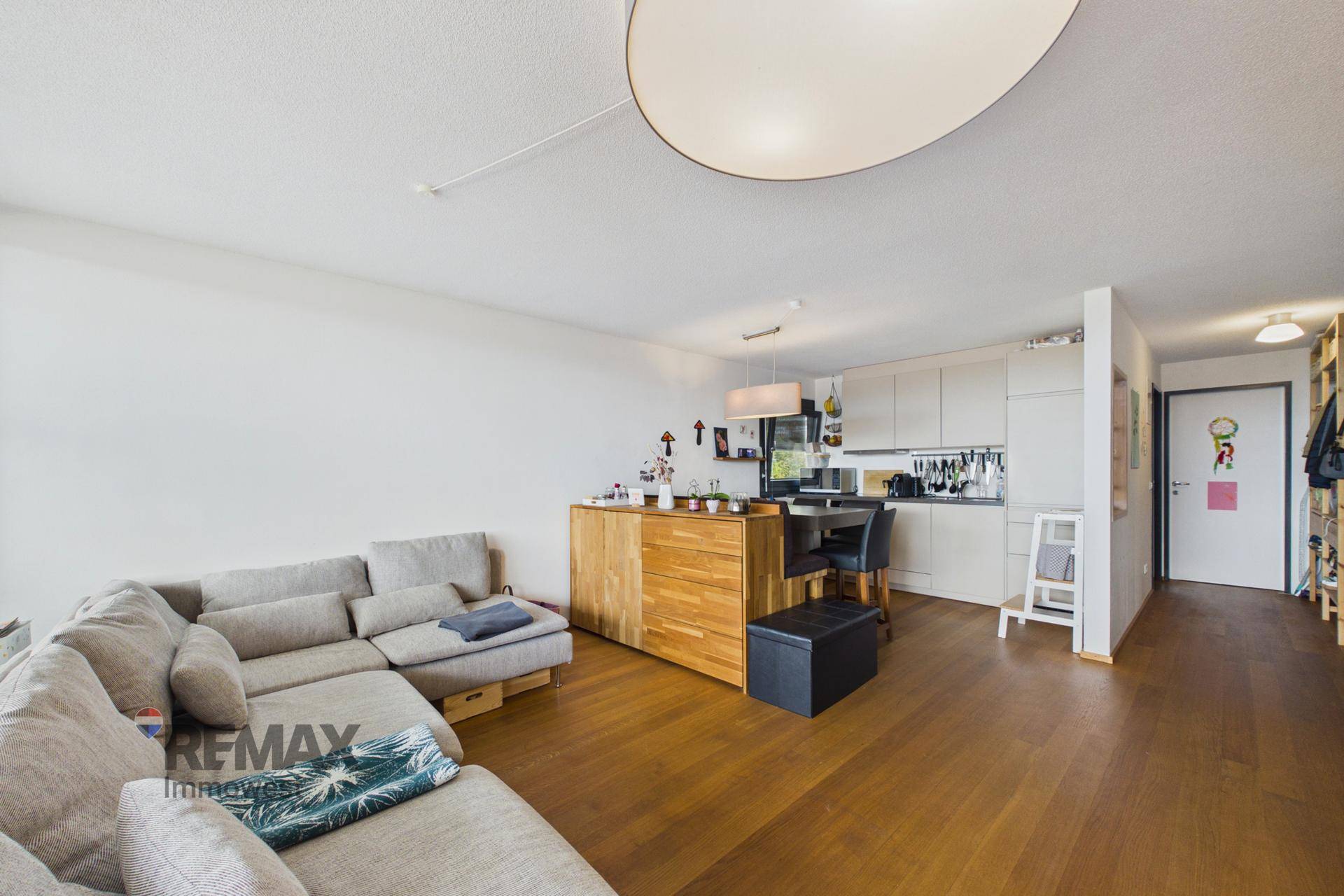 Gemütlicher Wohnbereich mit Sofa und integrierter Küchenzeile, ideal für offenes Wohnen.