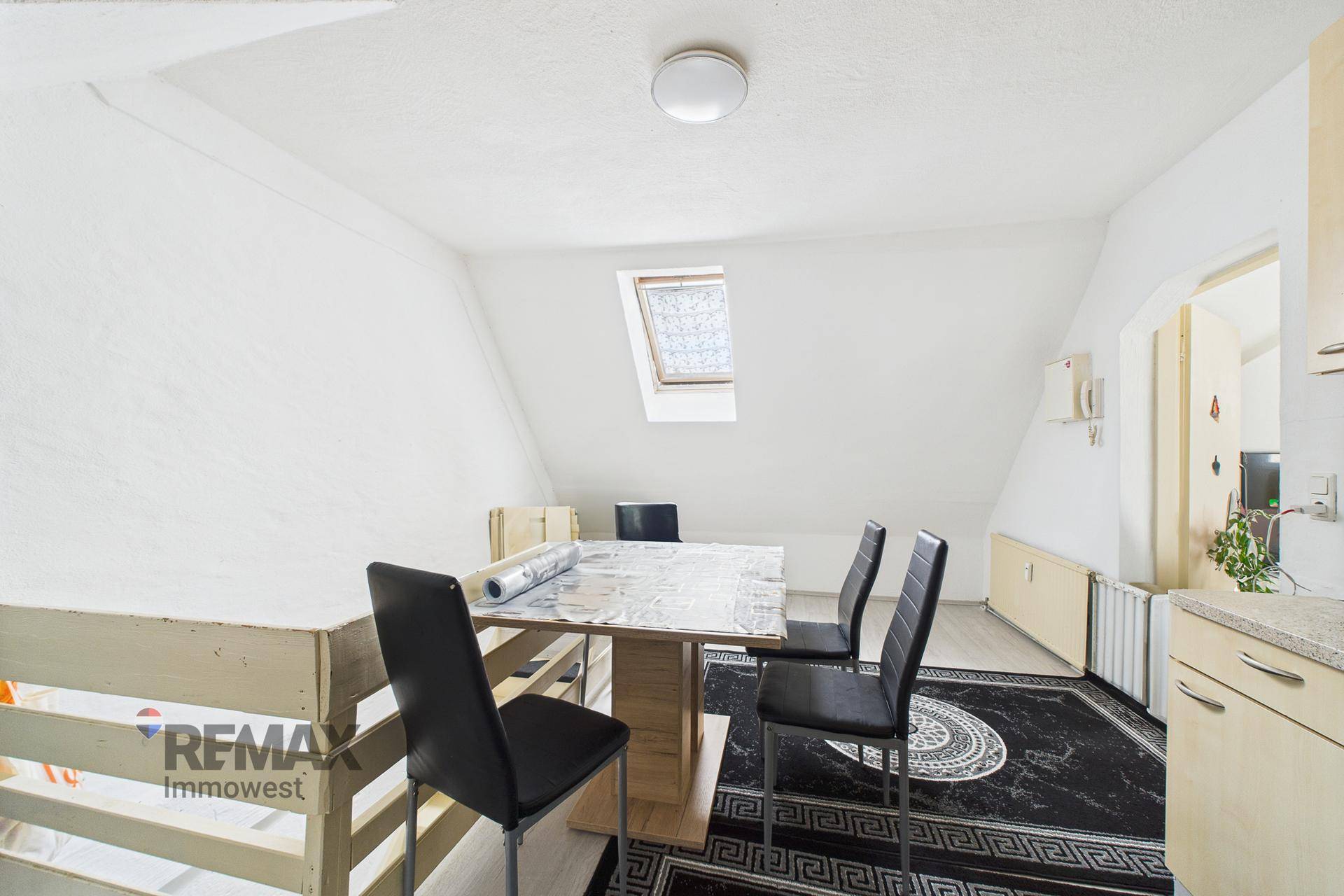Essbereich in der Küche mit Dachfenster und Zugang zu weiteren Räumen.