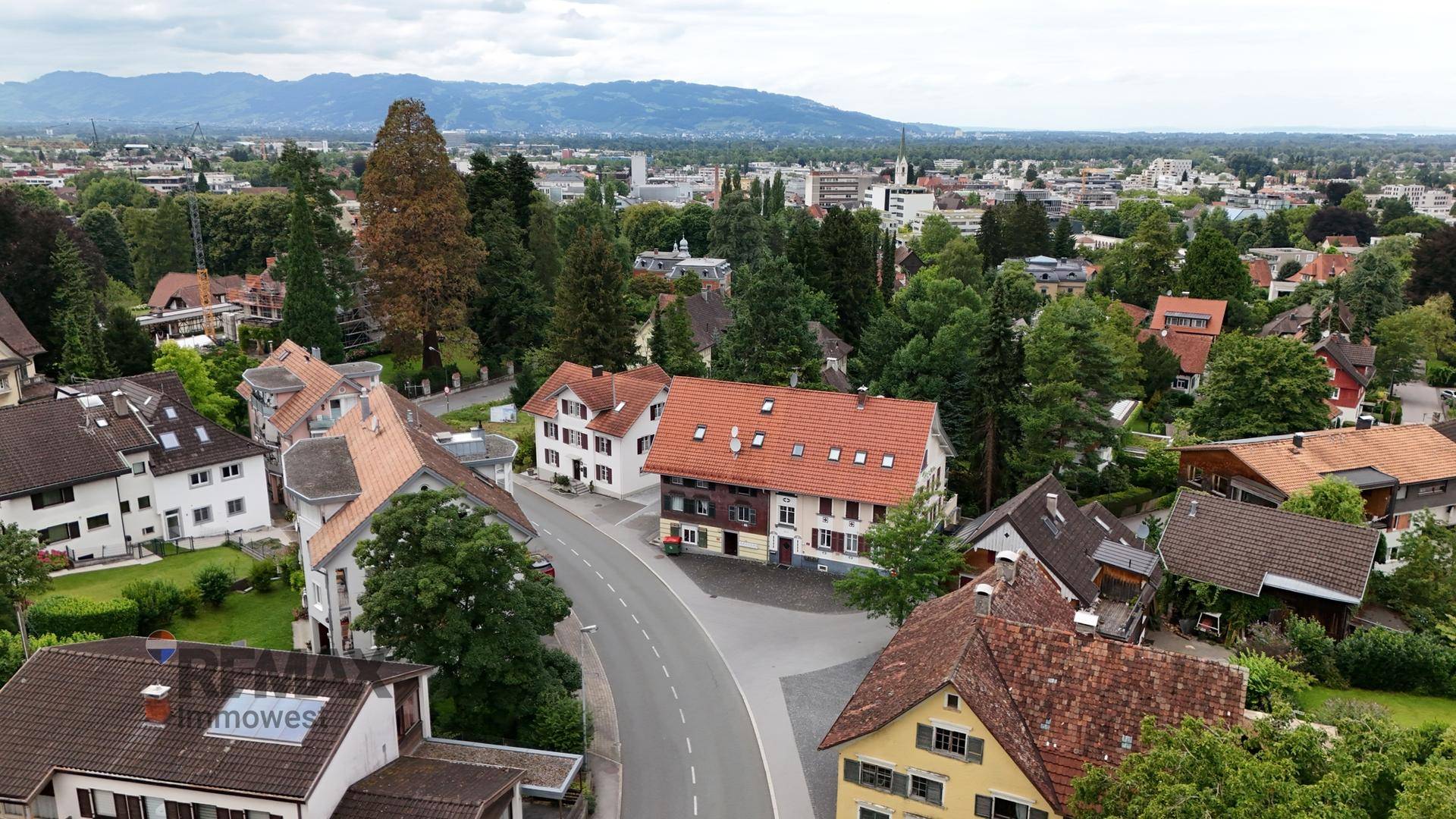 Panoramablick über die Stadt und die umliegende Landschaft mit Bergen im Hintergrund.