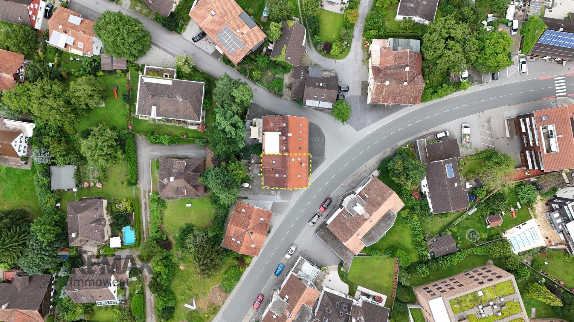 Weitläufige Luftaufnahme der Wohngegend mit vielen Grünflächen und Straßen.