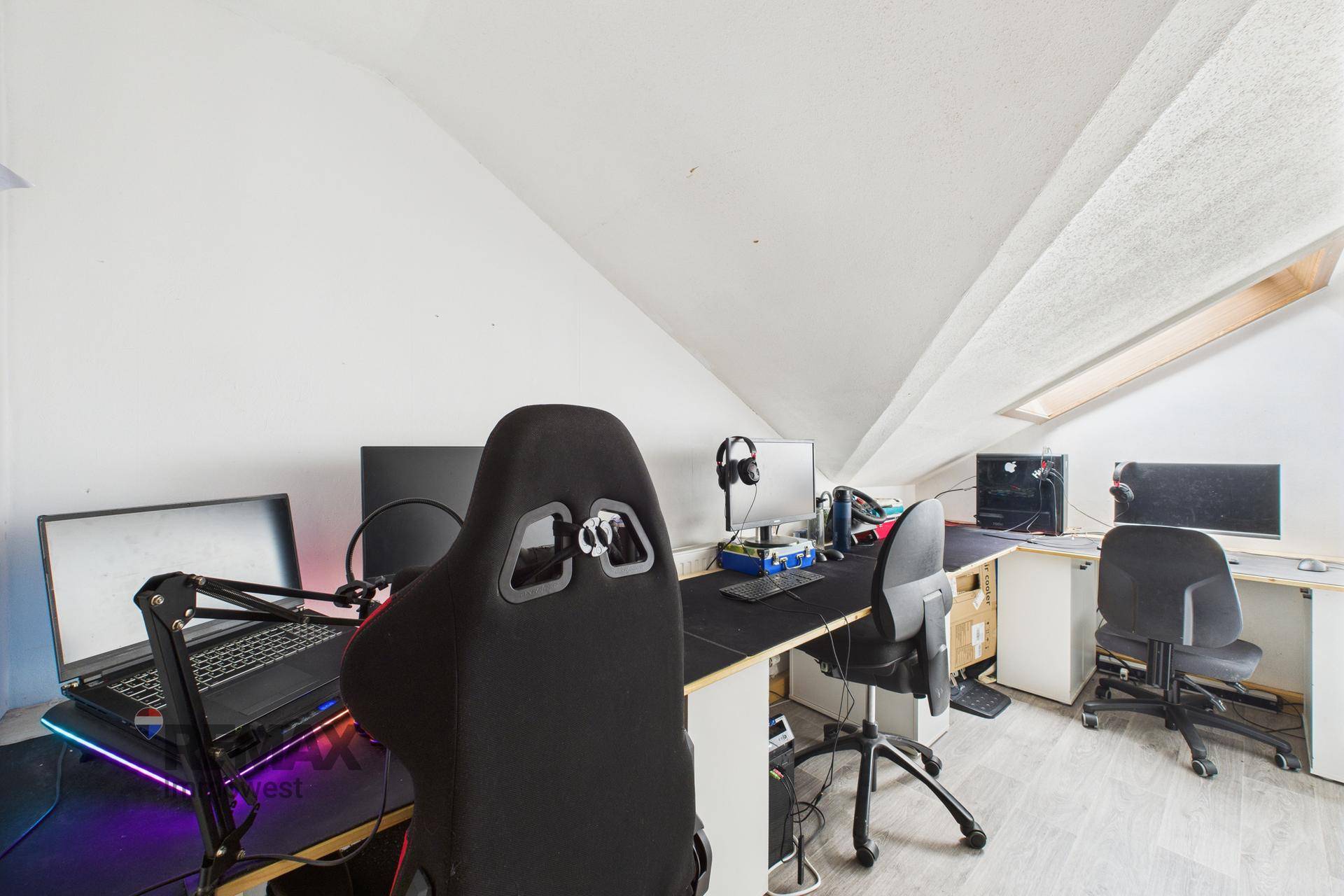 Dachgeschoss-Büro mit mehreren Arbeitsplätzen und Dachfenster für Gamer oder Homeoffice.