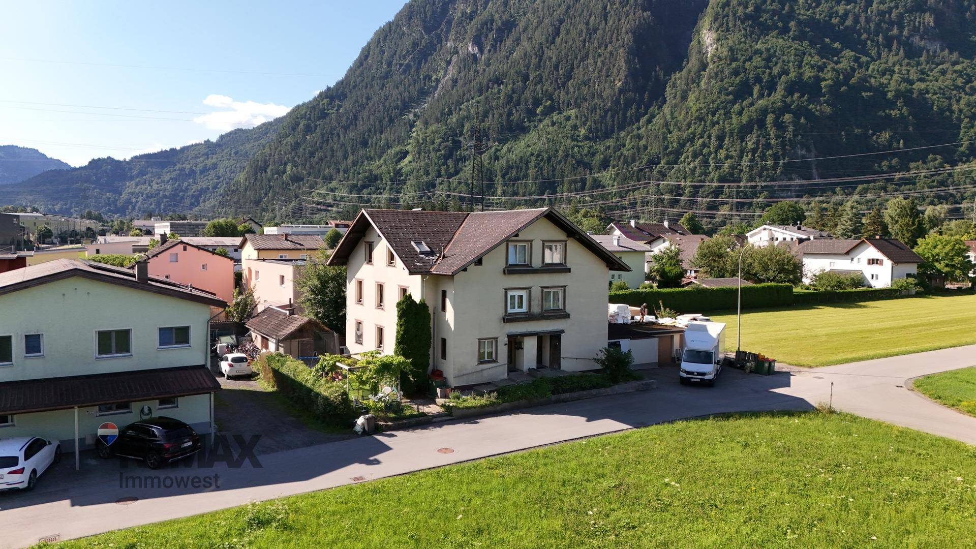 Übersicht des Einfamilienhauses in ländlicher Umgebung mit Bergblick und viel Grün.