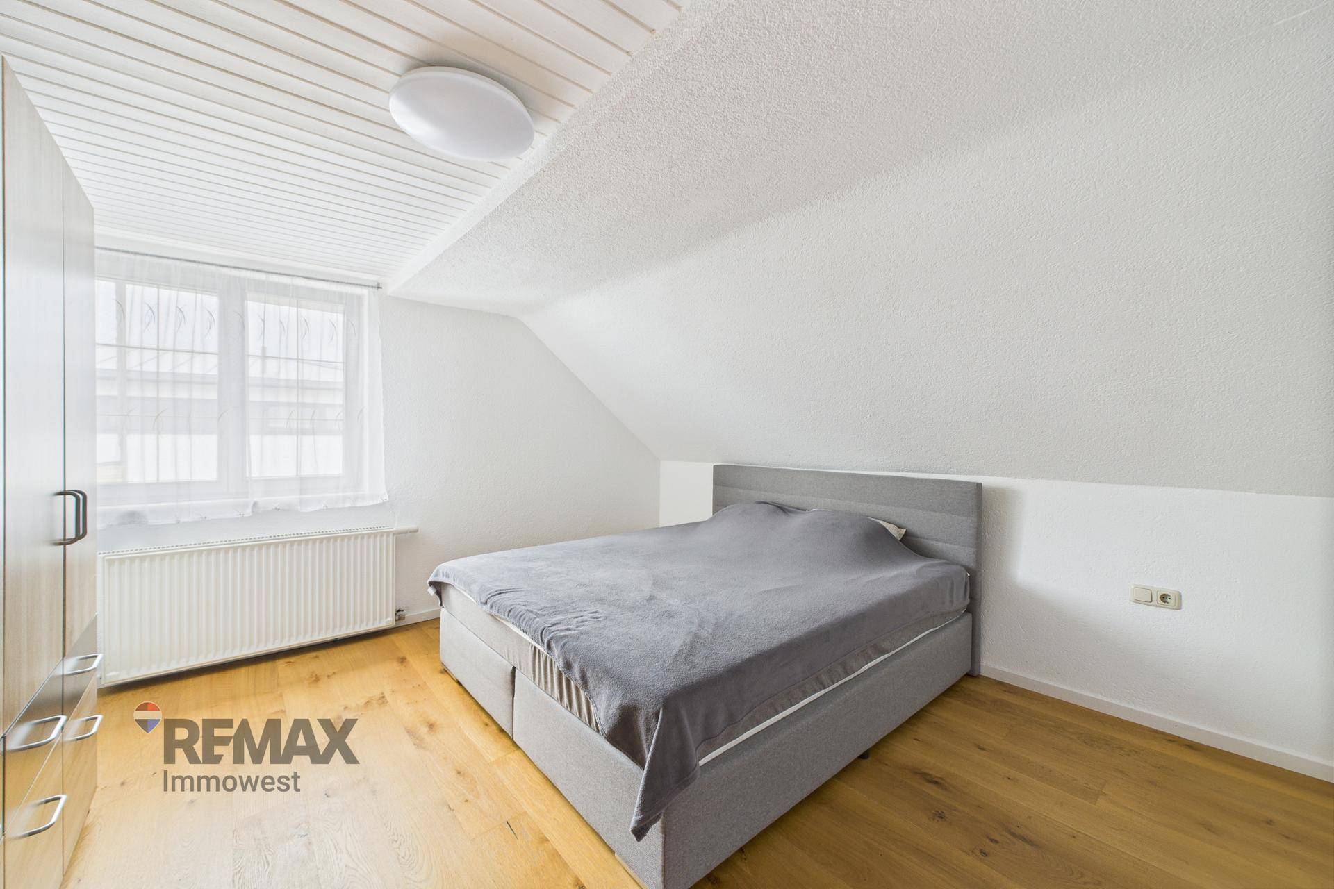 Gemütliches Schlafzimmer im Dachgeschoss mit Doppelbett, Holzboden und Dachschräge.