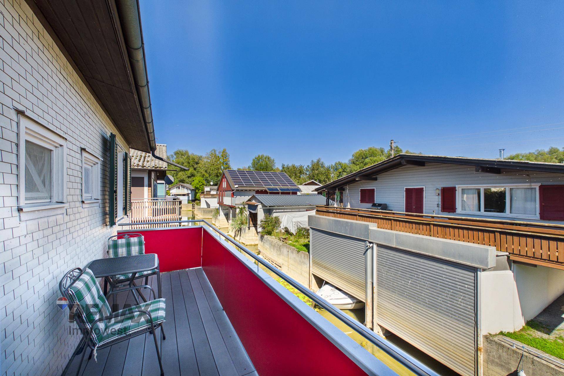 Kleiner Balkon mit Sitzgelegenheiten und Blick auf den Kanal und die umliegenden Häuser.