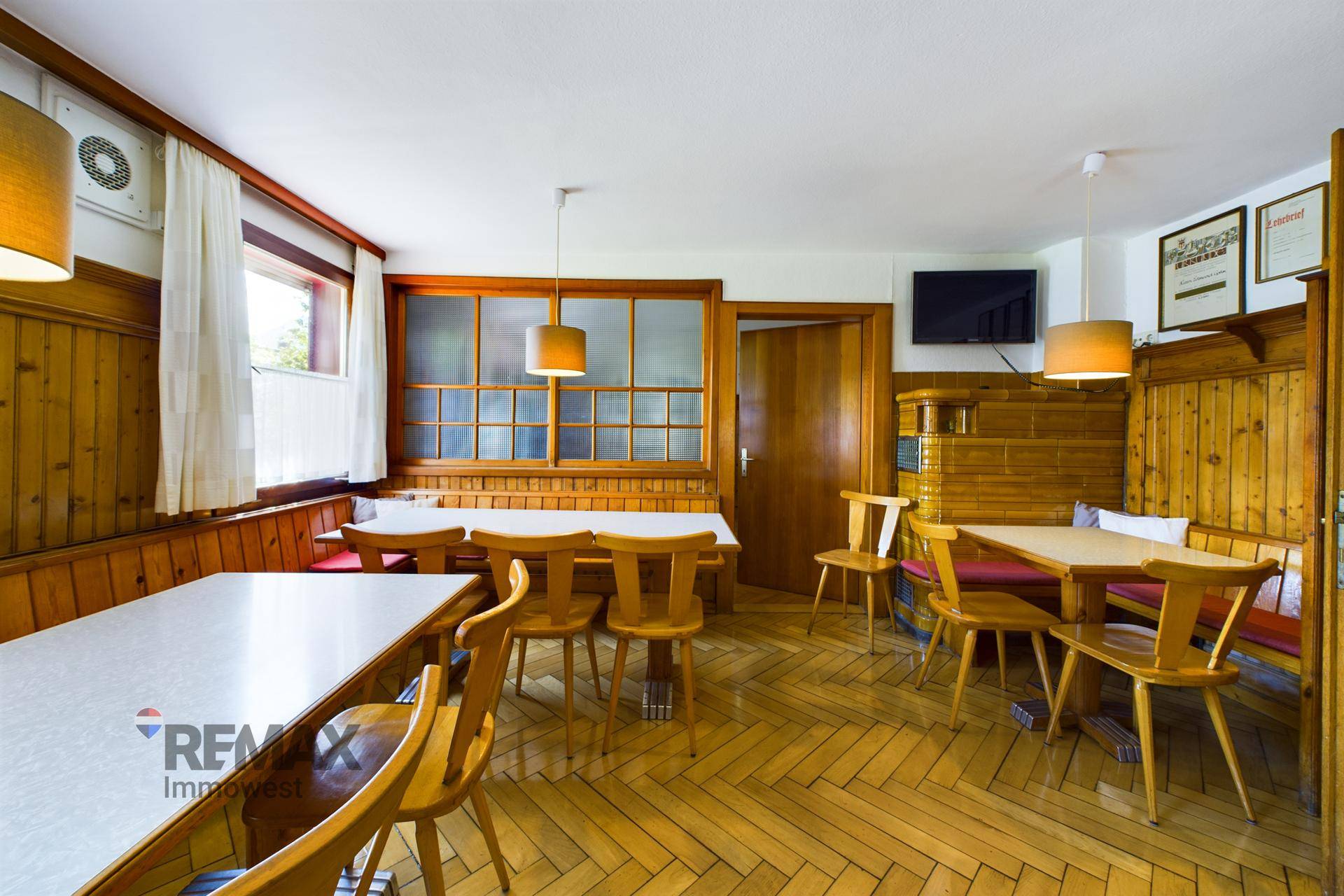 Rustikaler Essbereich mit Holzboden, Holztäfelung und traditionellen Sitzbänken und Tischen.