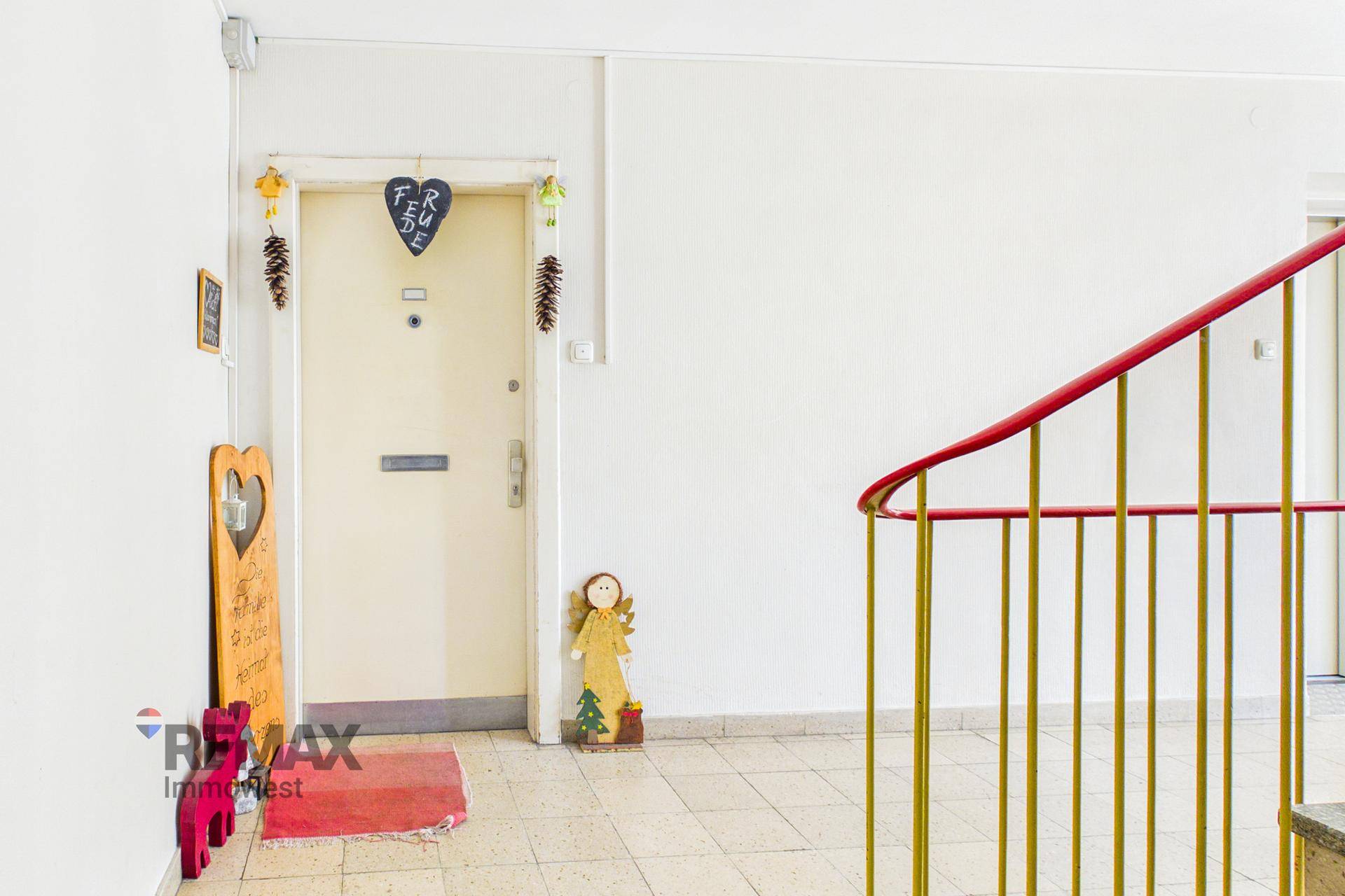 Eingangsbereich einer Wohnung mit Fliesenboden und Treppenaufgang.