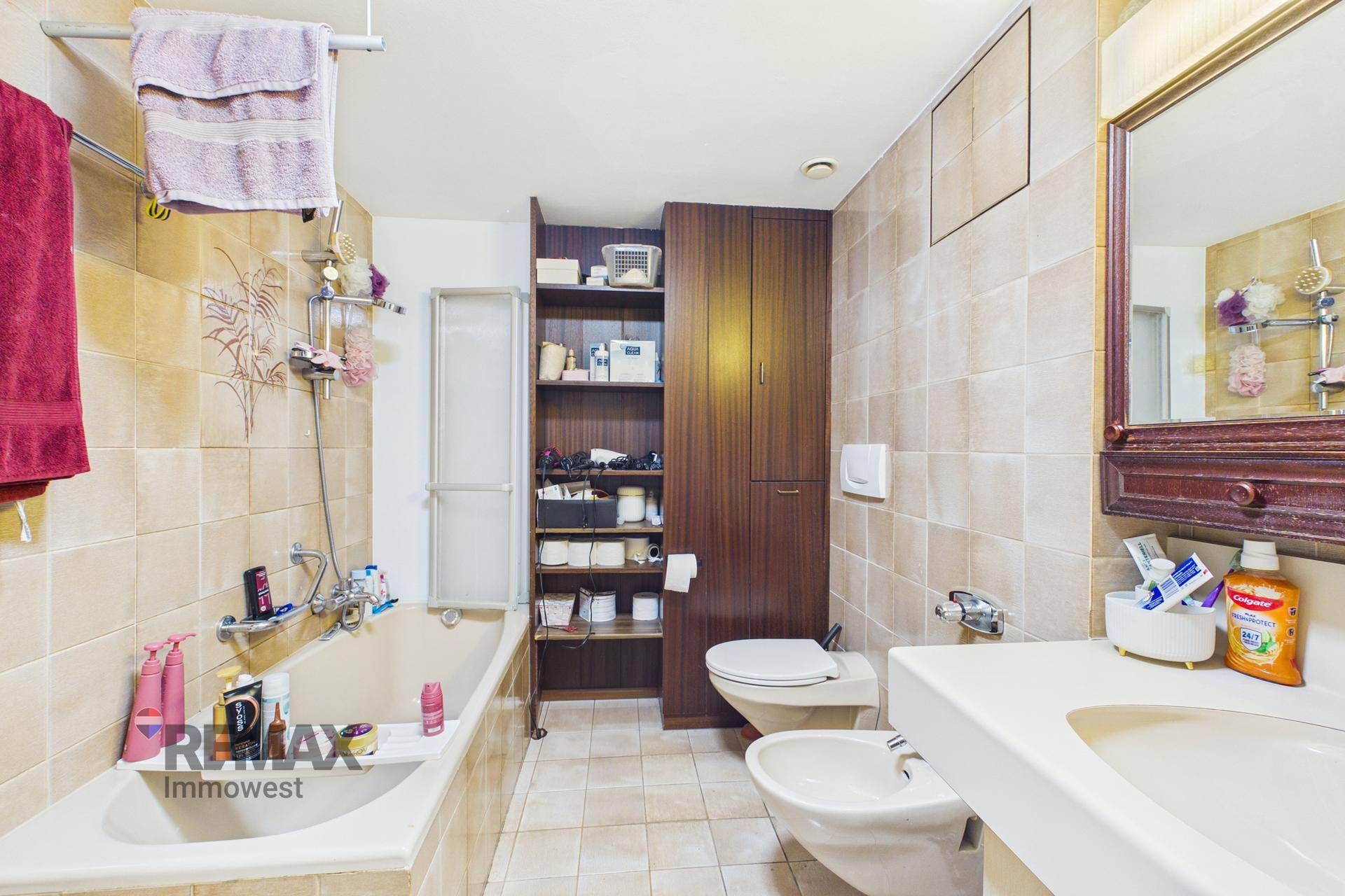 Badezimmer mit Badewanne, WC, Bidet und Fliesen an Wänden und Boden.