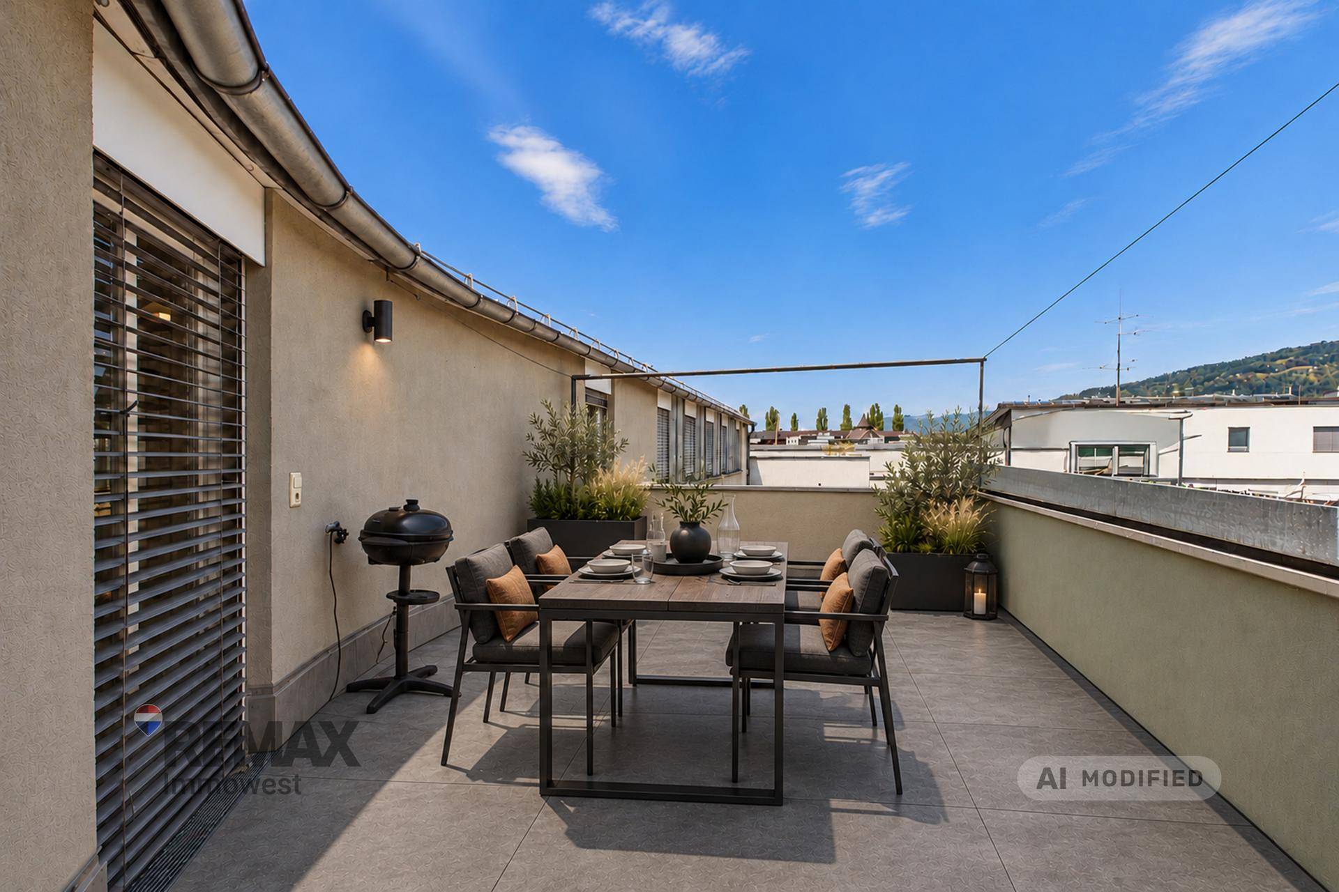Möblierte Dachterrasse mit Essbereich, Grill und Blick auf die umliegende Landschaft.