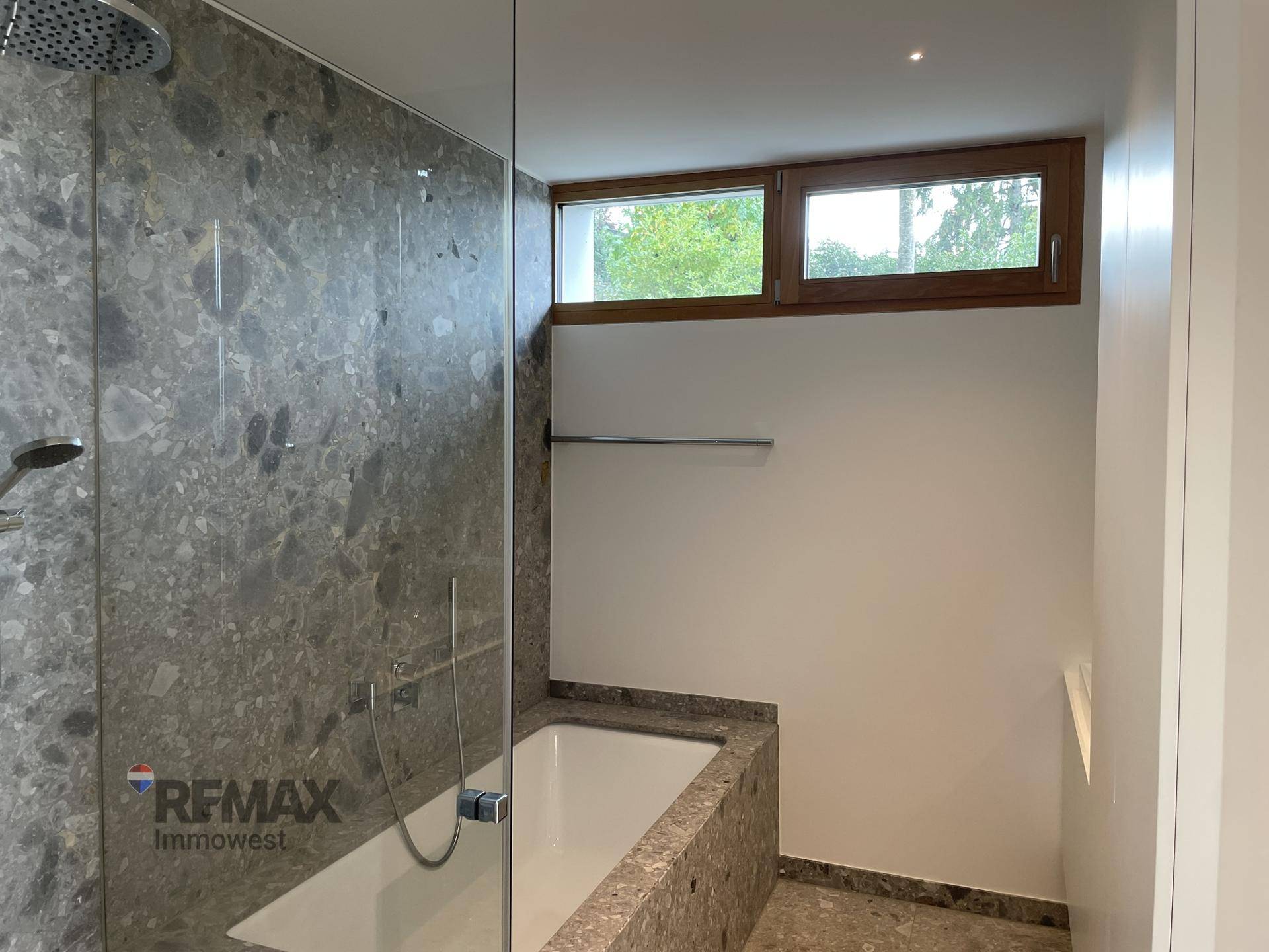 Elegantes Badezimmer mit Dusche, Badewanne und einem Fenster für natürliches Licht.