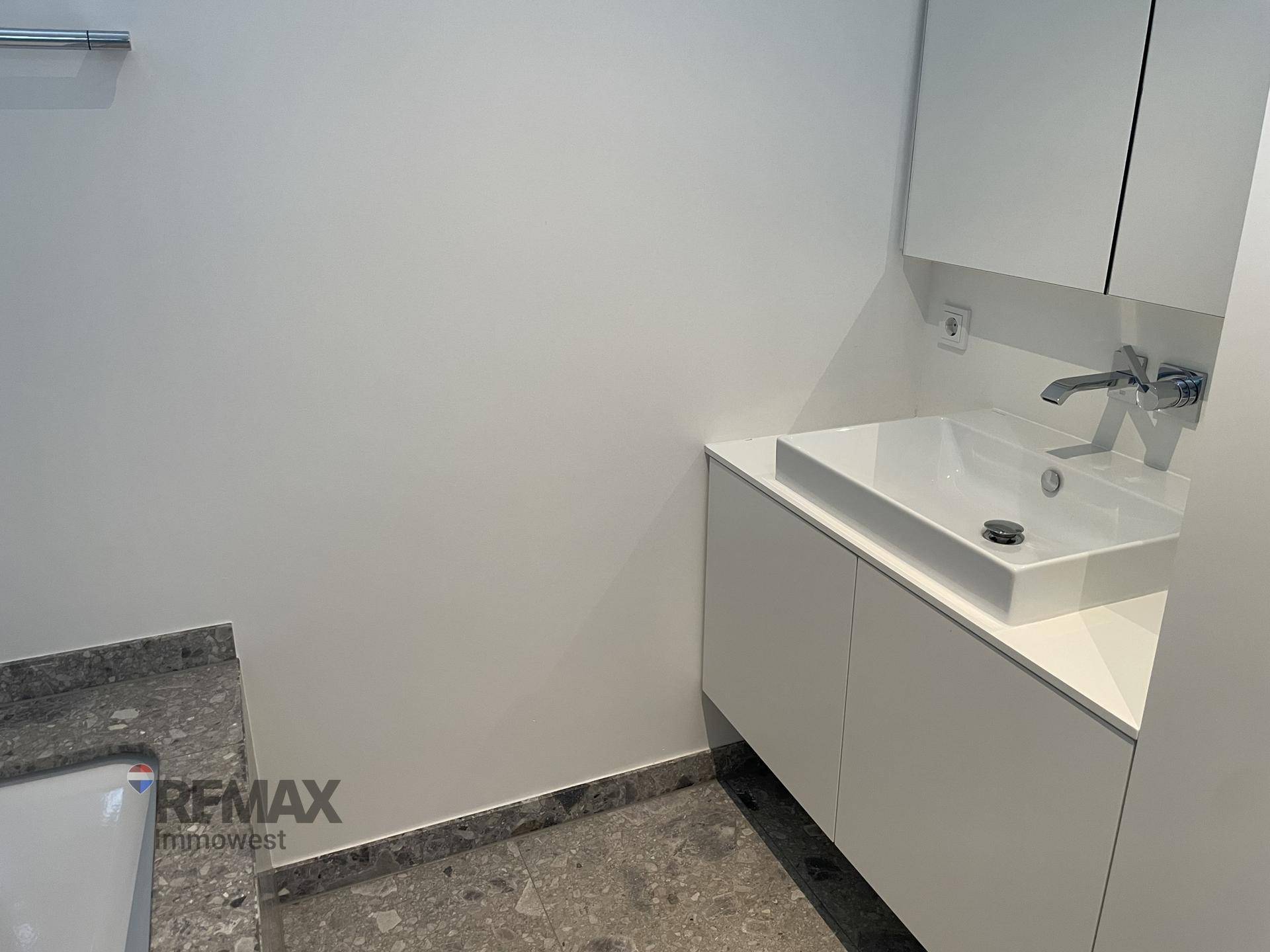 Funktionales Badezimmer mit weißem Waschtischunterschrank, Einzelwaschbecken und Spiegelschrank.