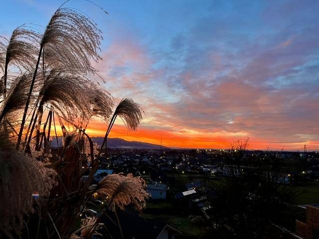 Spektakulärer Sonnenuntergang über der Stadt mit leuchtenden Farben am Horizont.