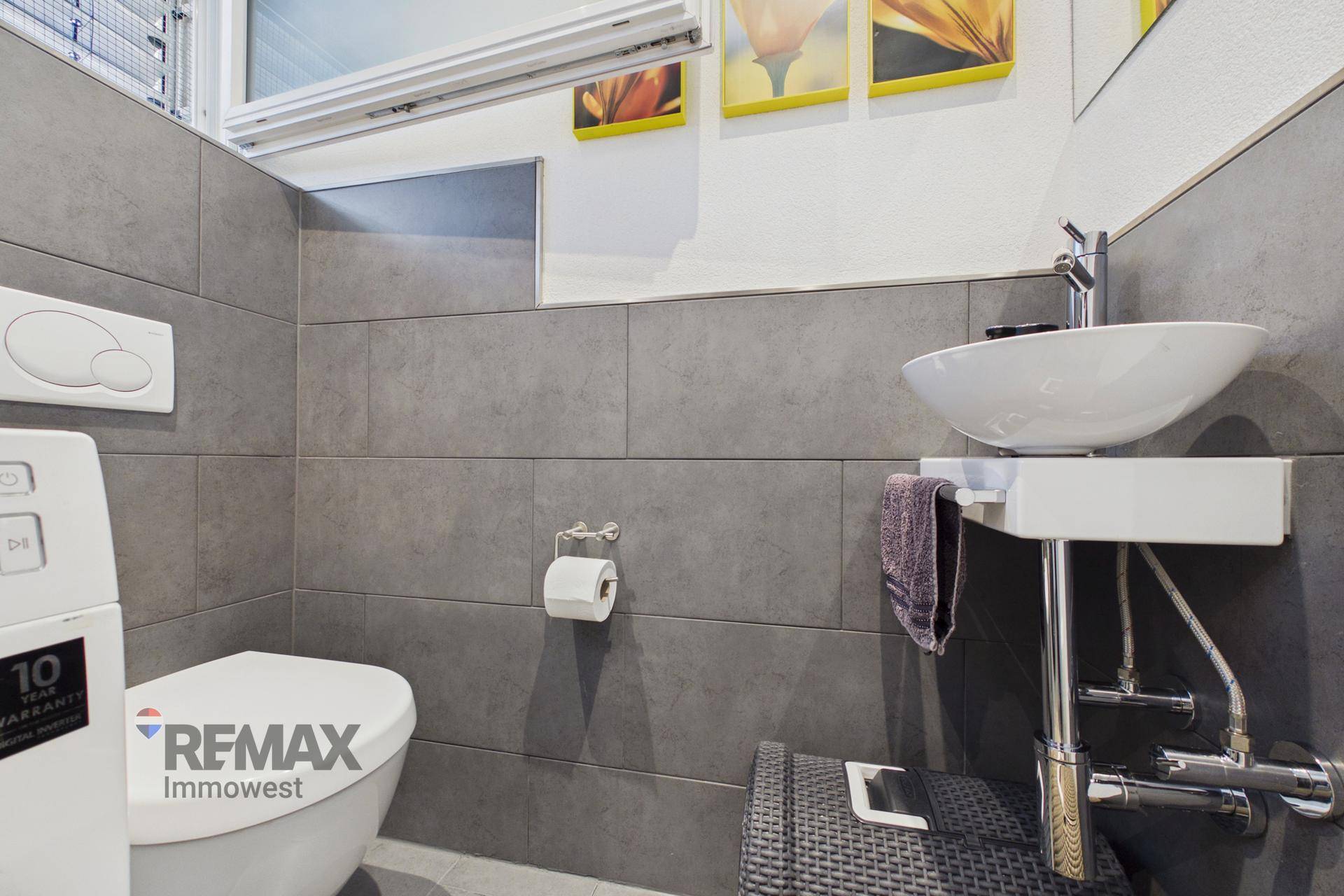 Kleines Gäste-WC mit modernem Waschbecken und Wand-WC, in schlichtem Design.