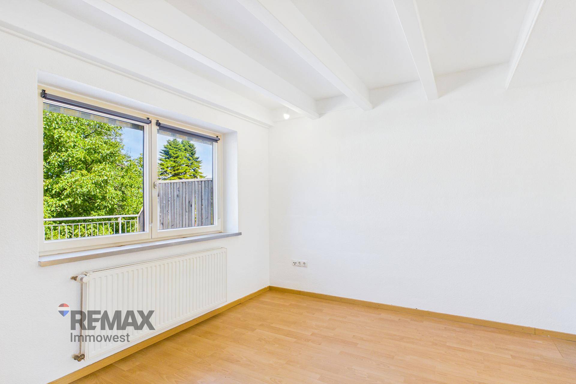 Heller Raum mit Holzboden und Fenster mit Blick ins Grüne und französischem Balkon, sehr einladend.