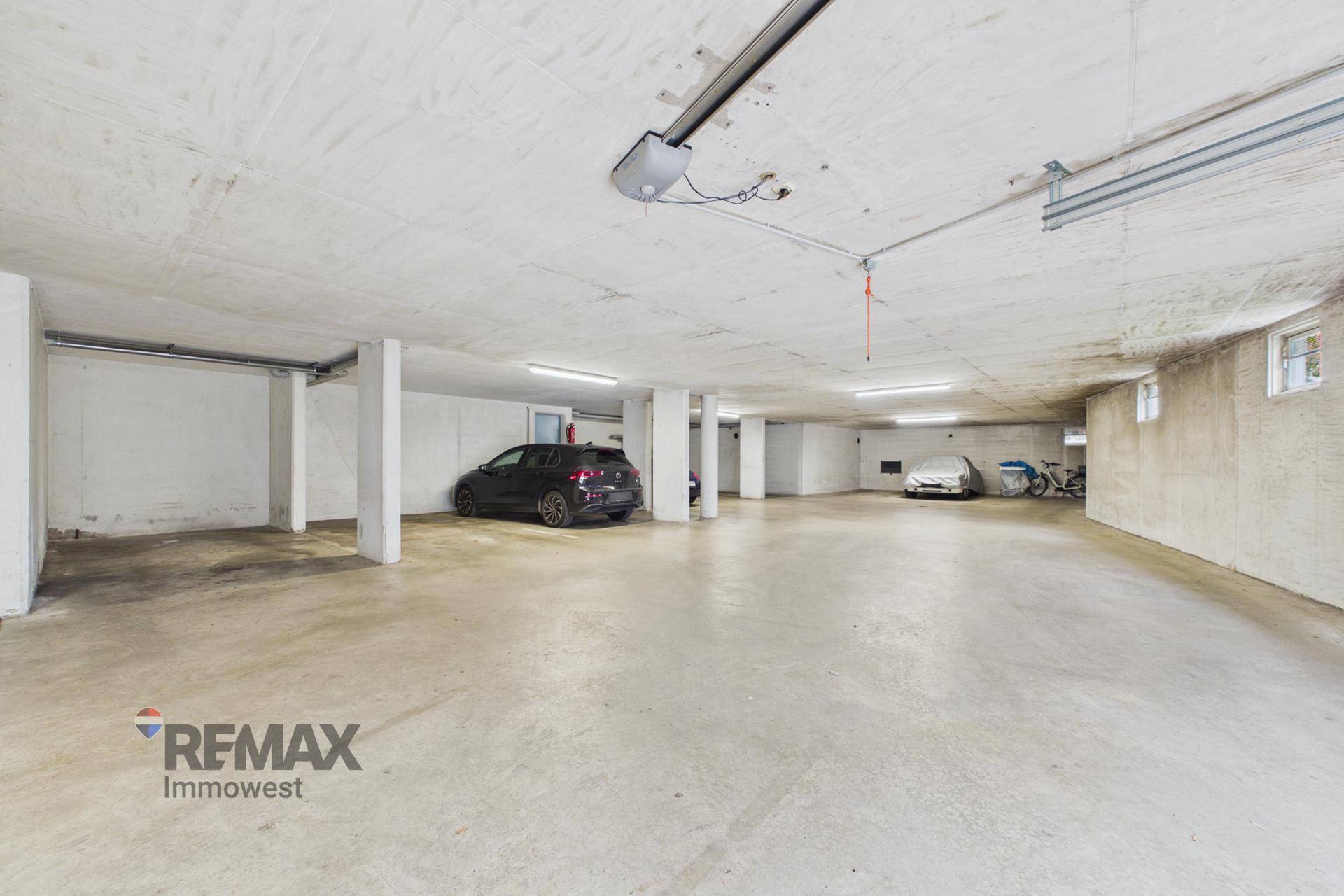 Geräumige Tiefgarage mit Betonboden, Säulen und mehreren Stellplätzen.